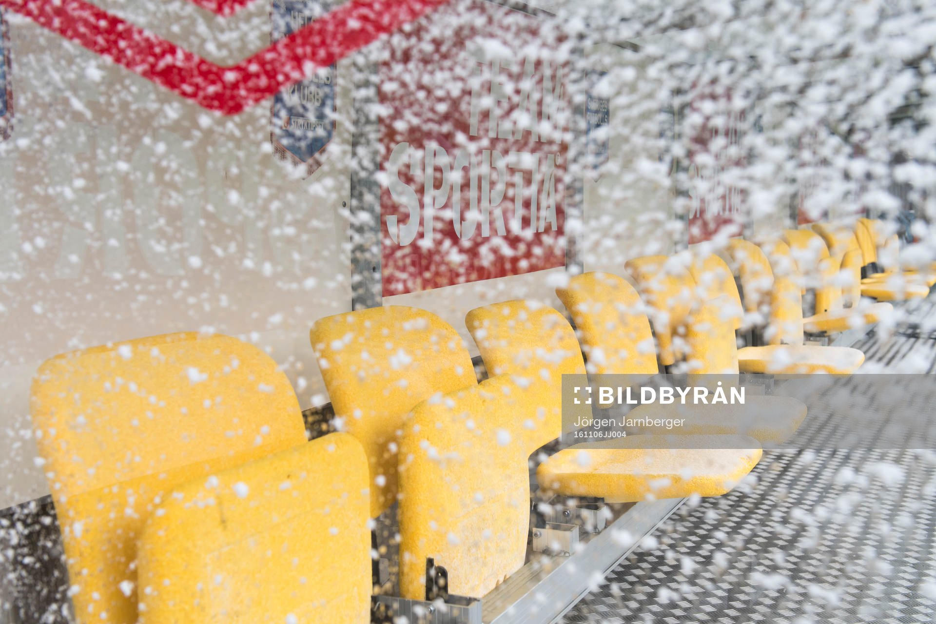 Snö på stolarna för spelarna innan fotbollsmatchen i