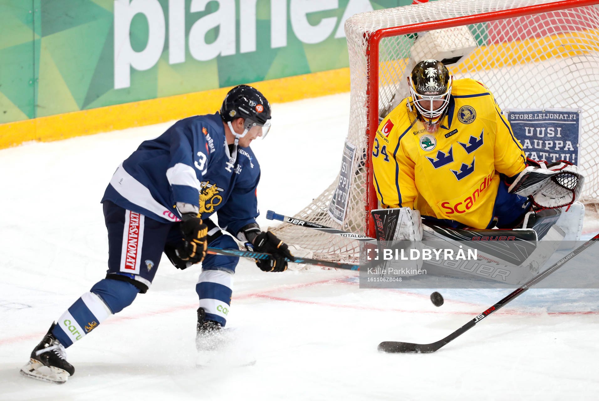 Finland¥s Mika Pyörälä and Sweden¥s goalie Joel