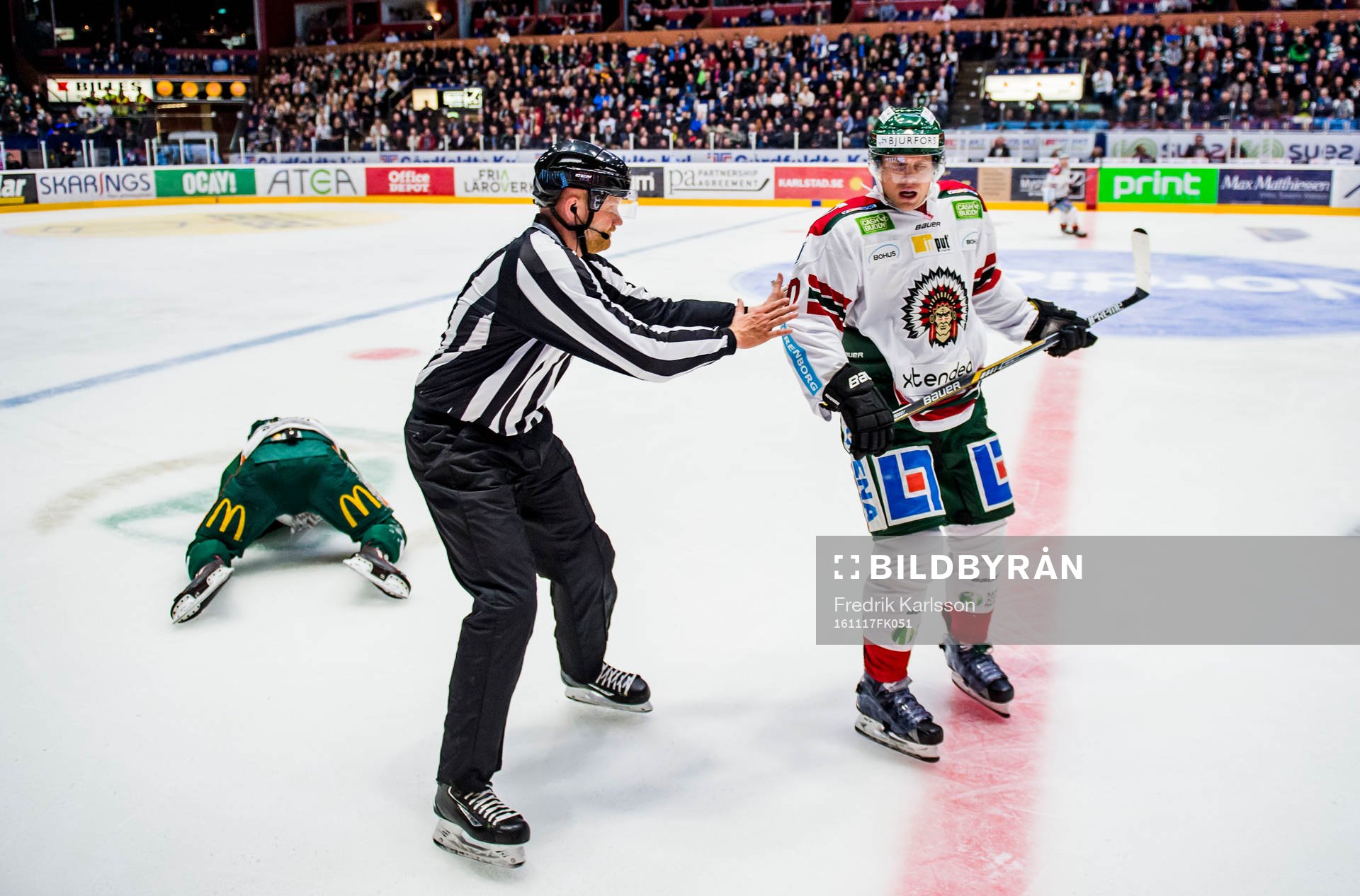 Färjestads Oskar Steen ligger på isen och blöder medans