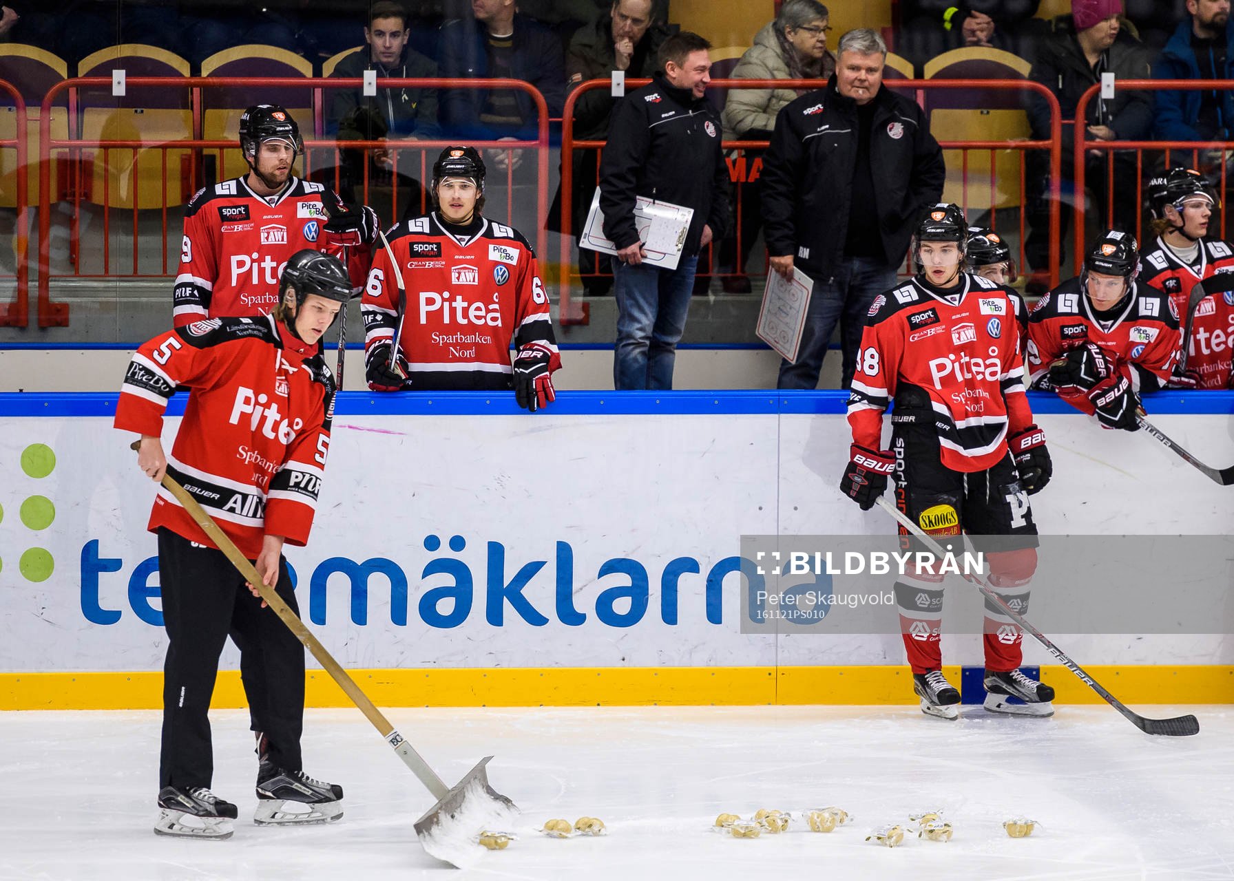 En funktionär skotar upp palt från isen