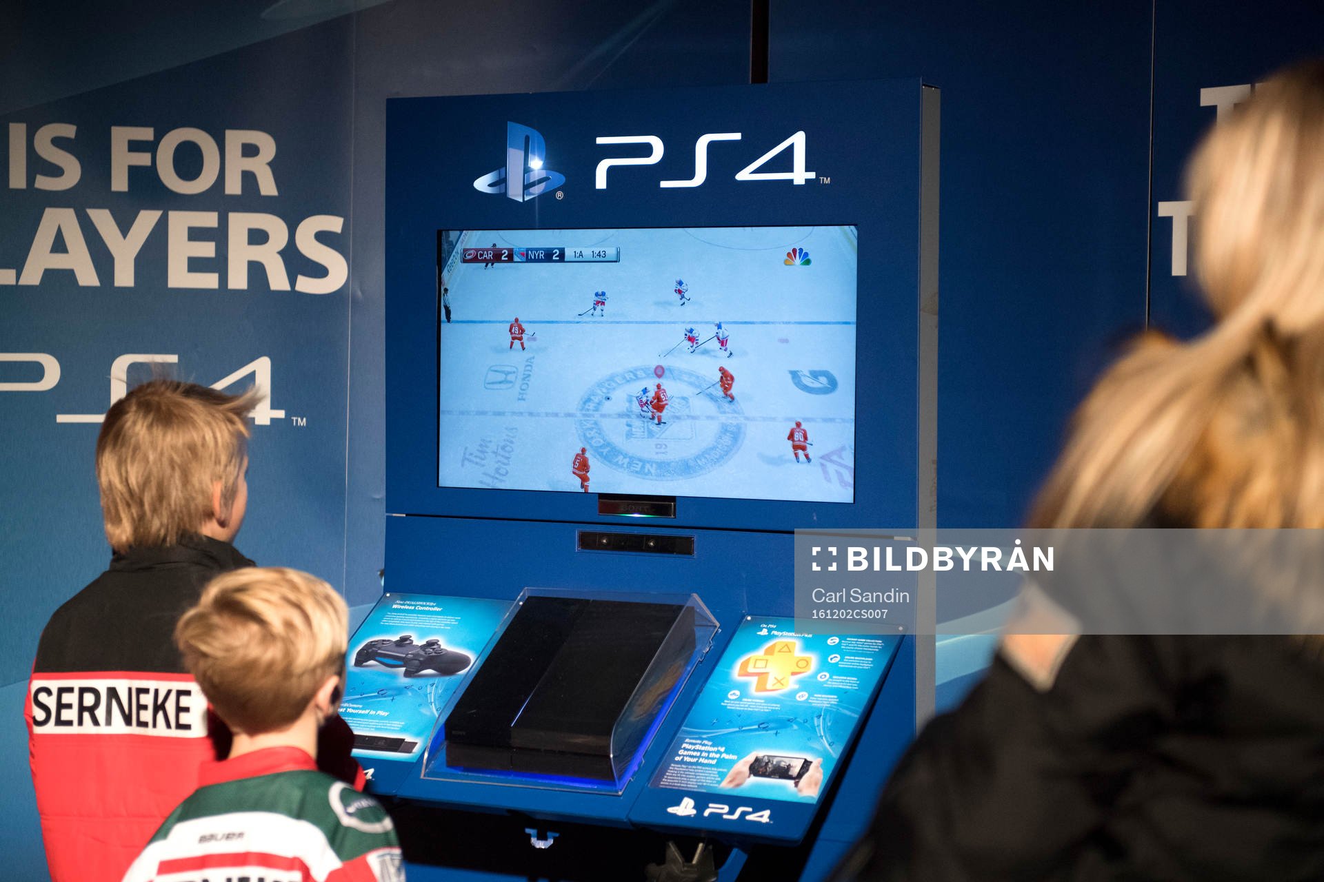 Två ungdomar spelar tv-spel innan ishockeymatchen i SHL