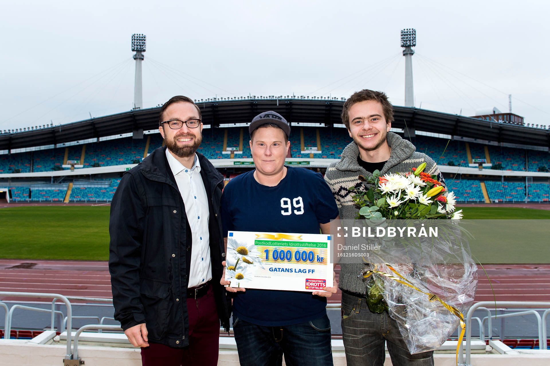 Martin Kihlström från Postkodlotteriet delar ut en check