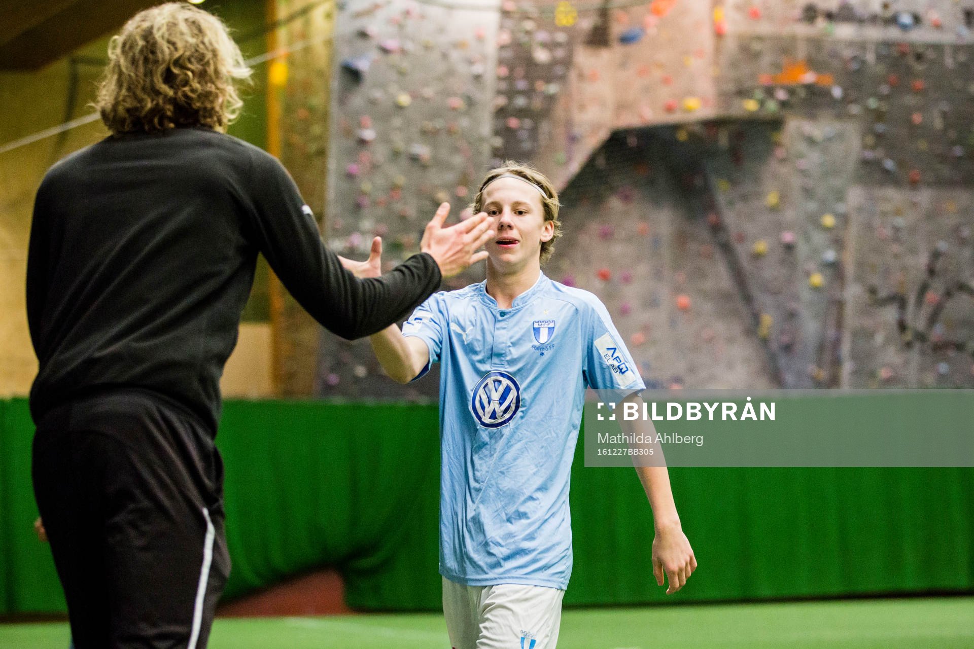 Spelare i Malmö FF gör high five med ungdomsledare