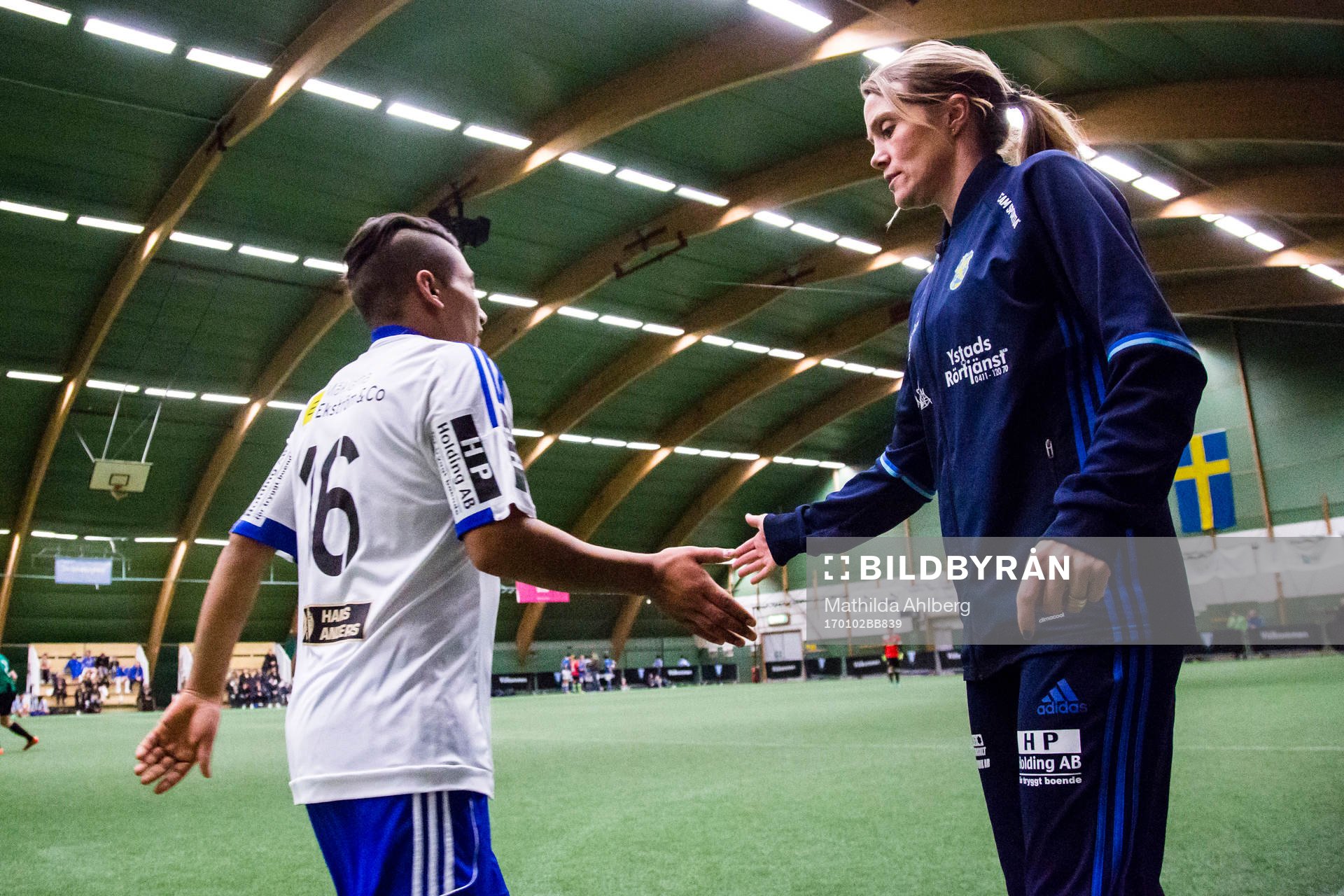 Ungdomsledare tar i hand med spelare vid ett byte