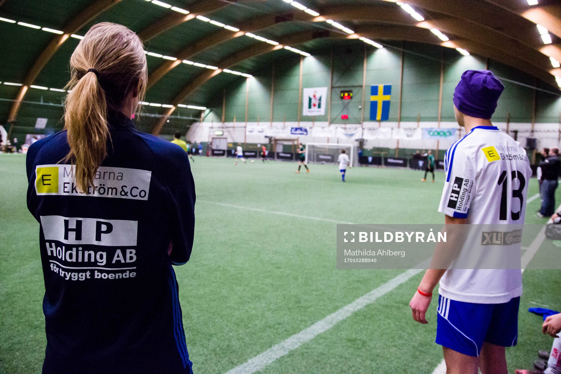 Ungdomsledare och spelare tittar på match
