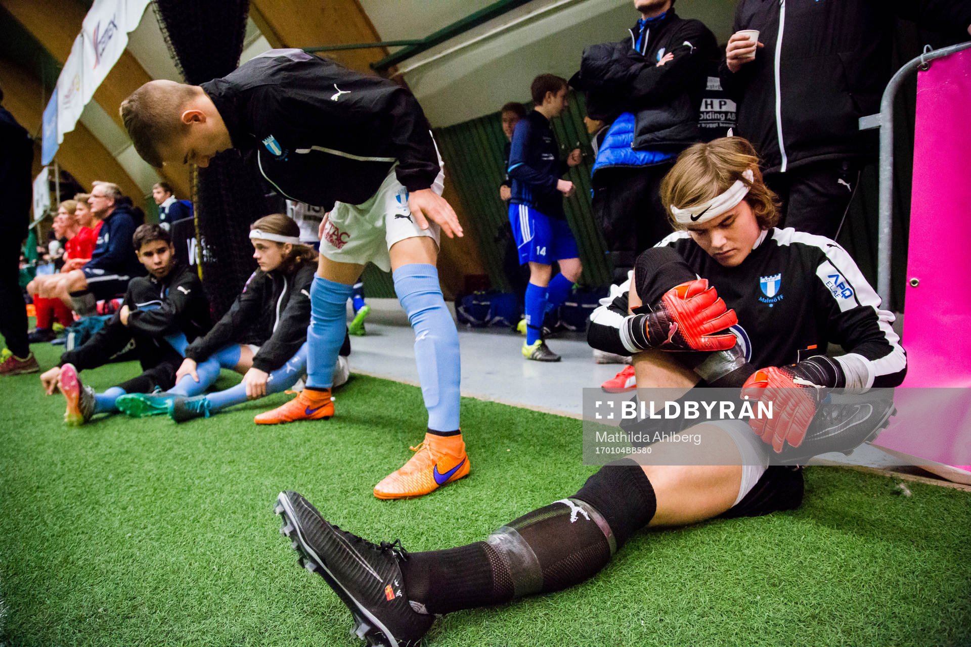 Spelare ur Malmö FF värmer upp och tittar på match
