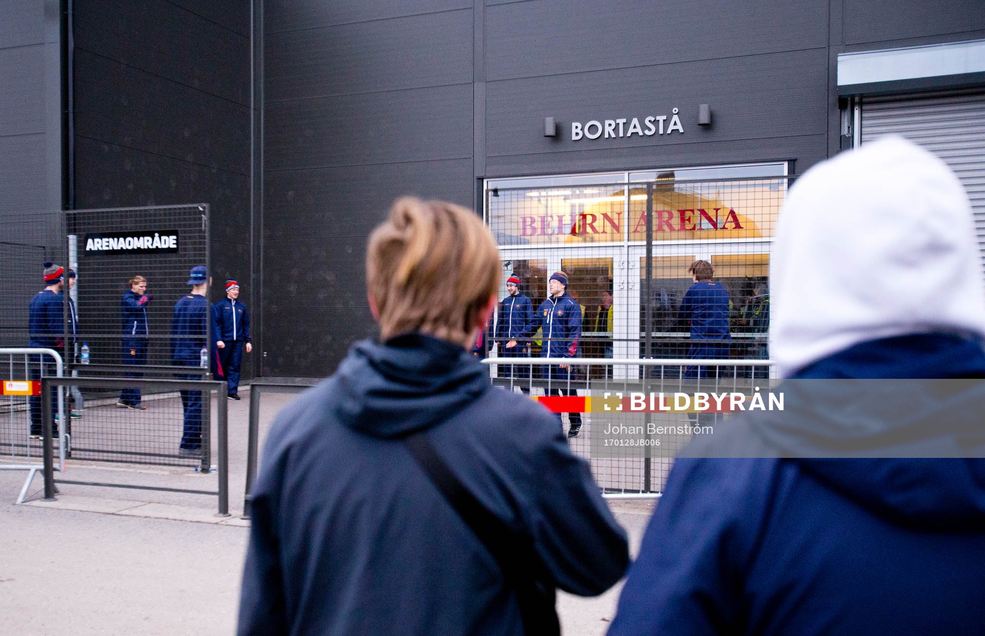 Några ungdomar tittar på Djurgårdensspelarna som värmer