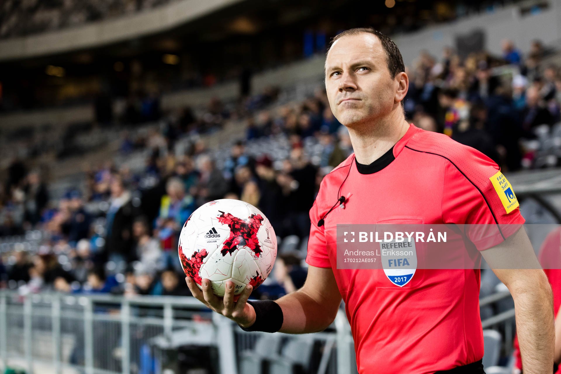Domare Jonas Eriksson går in på plan med matchbollen