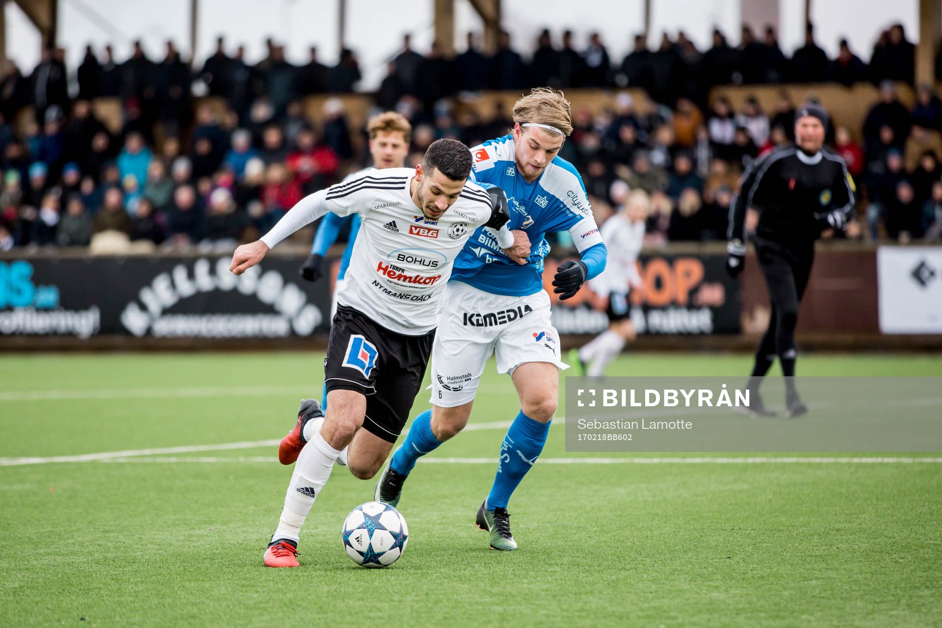Vänersborgs Andelo Vekic före Halmstads Marcus Mathisen under fotbollsmatchen i gruppspelet i Svenska Cupen mellan Vänersborg och Halmstad den 18 februari 2017 i Vänersborg.