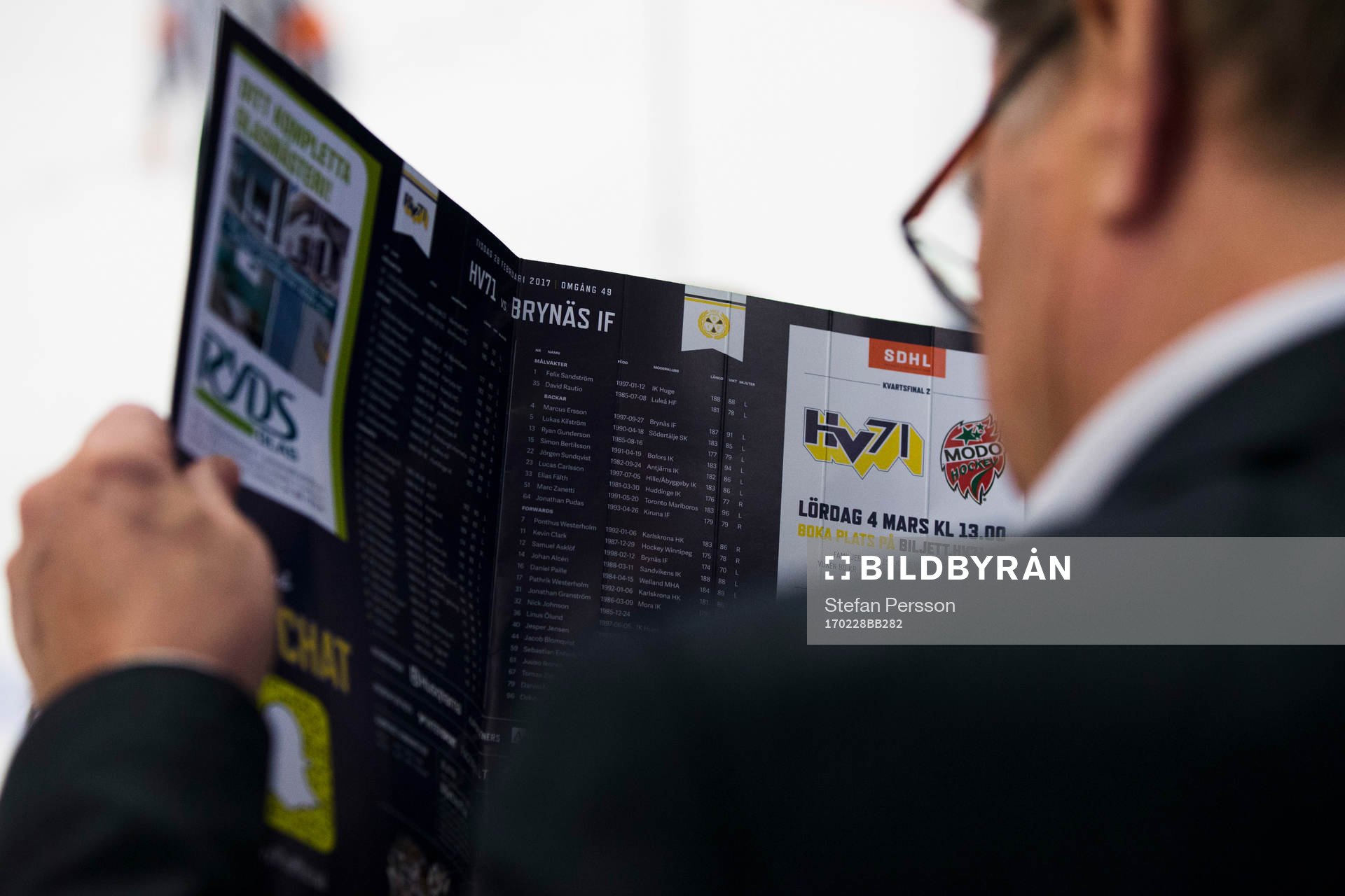 Åskådare läser i matchprogrammet