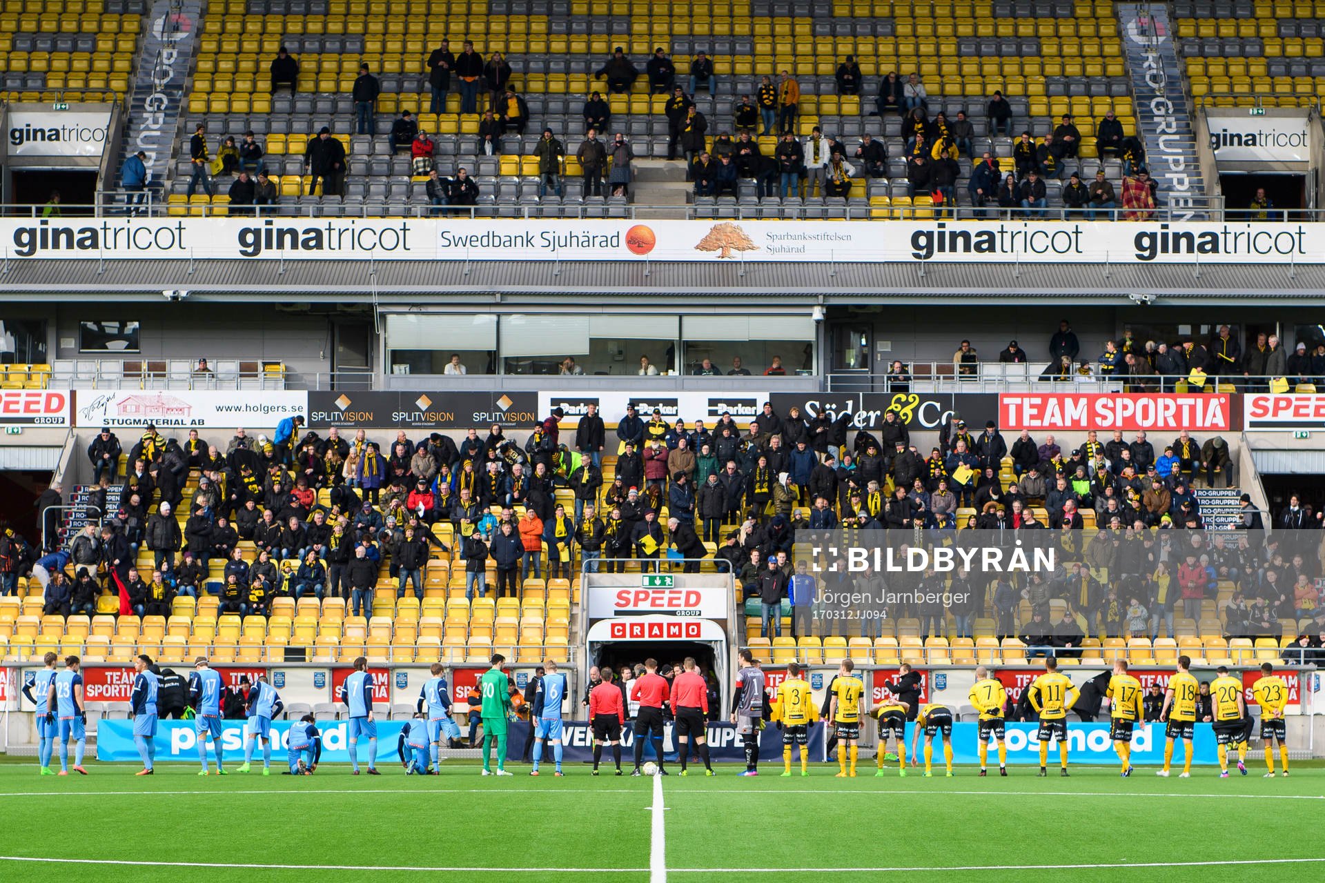 Domarna och spelarna kommer in till fotbollsmatchen i