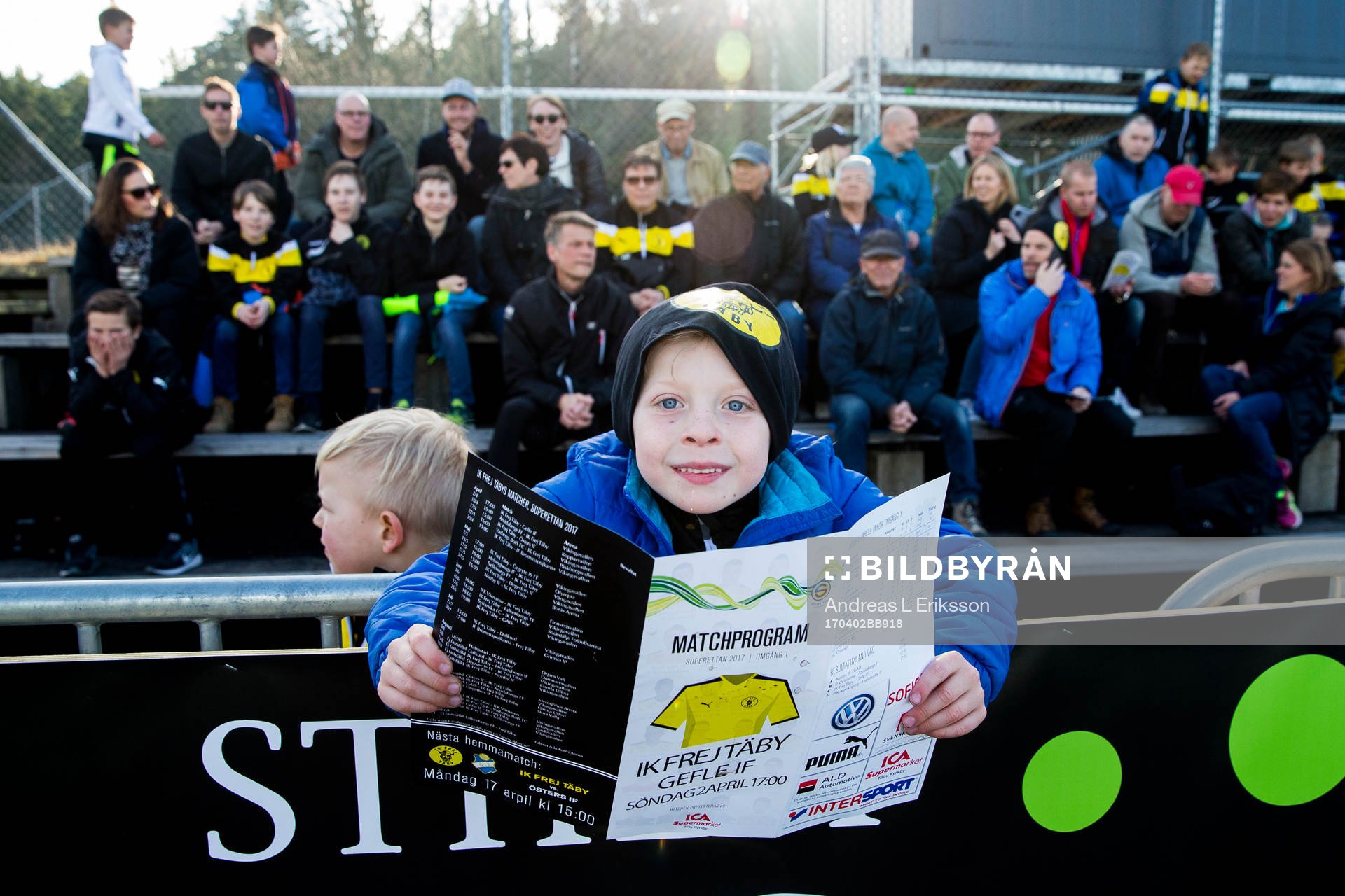 En ung Frejsupporter läser matchprogrammet