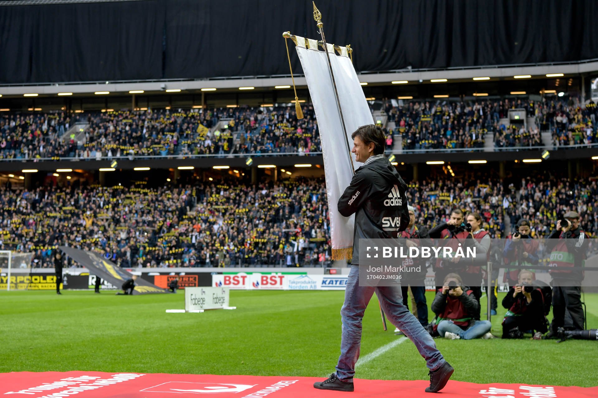 aren Ivan Obolo gör entre med fanan  fotbollsmatchen i
