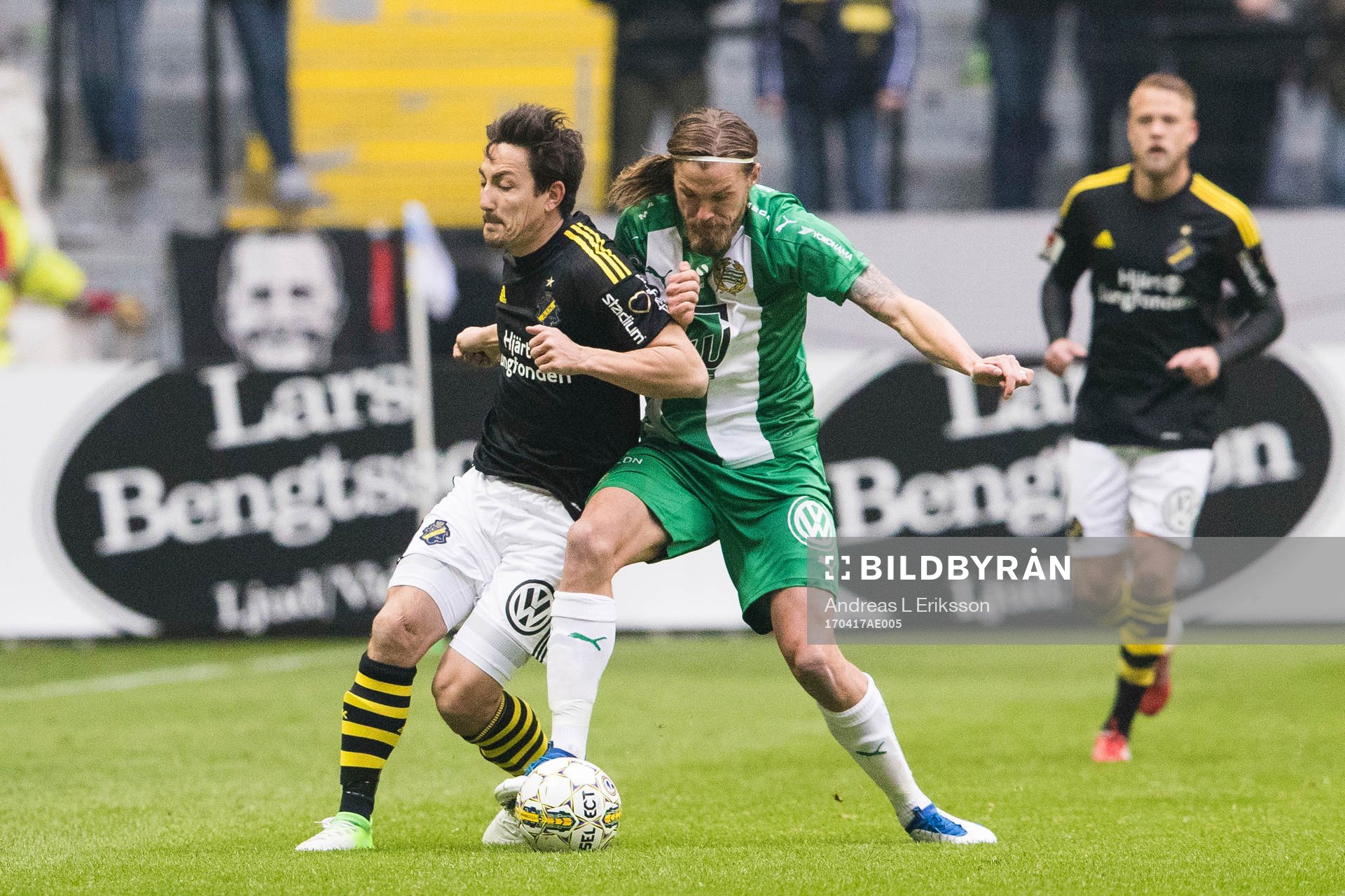 AIK:s Stefan Ishizaki i kamp om bollen med Hammarbys Björn Paulsen under fotbollsmatchen i Allsvenskan mellan AIK och Hammarby den 17 april 2017 i Stockholm. 