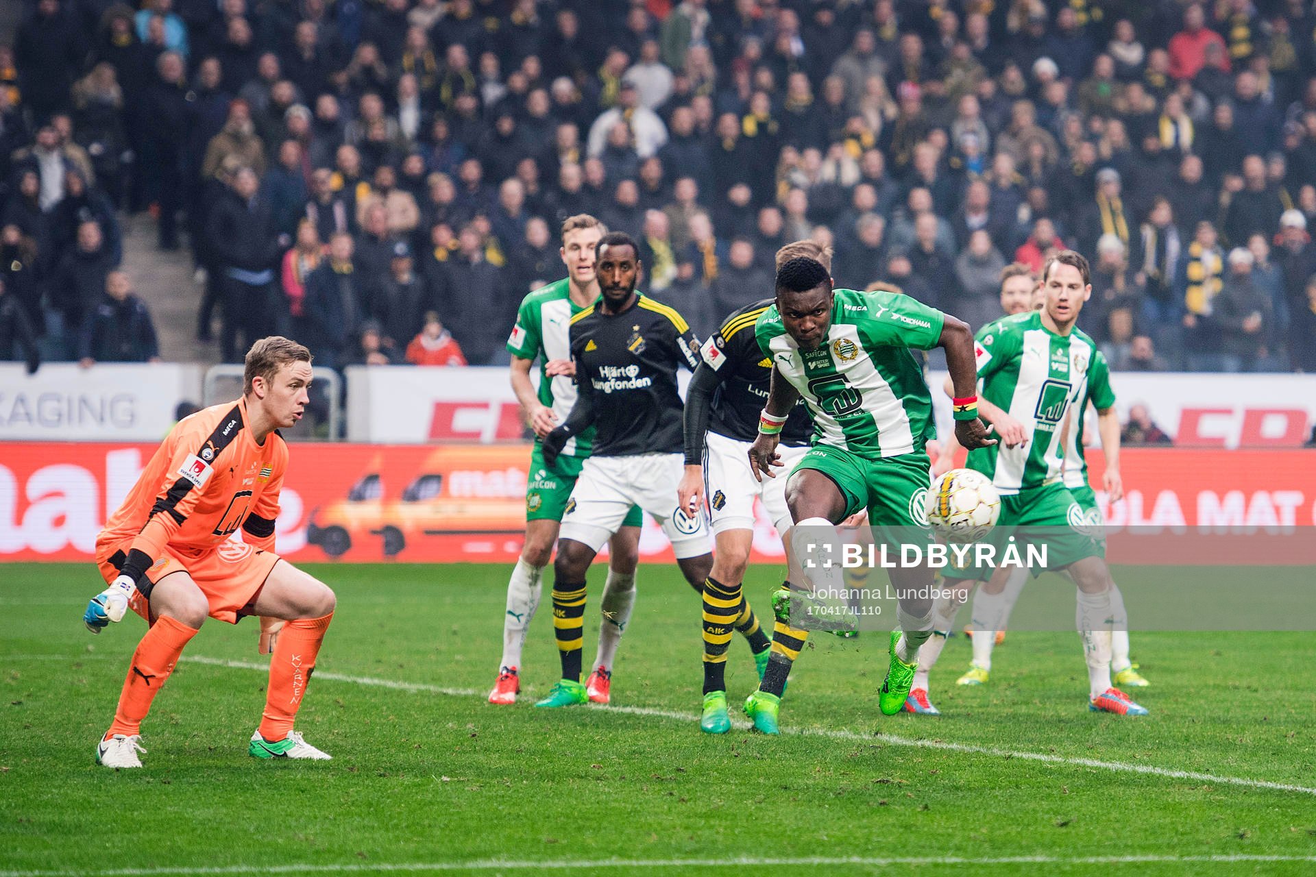 Hammarbys Joseph Aidoo rensar framför målvakt Ögmundur Kristinsson under fotbollsmatchen i Allsvenskan mellan AIK och Hammarby den 17 april 2017 i Stockholm.