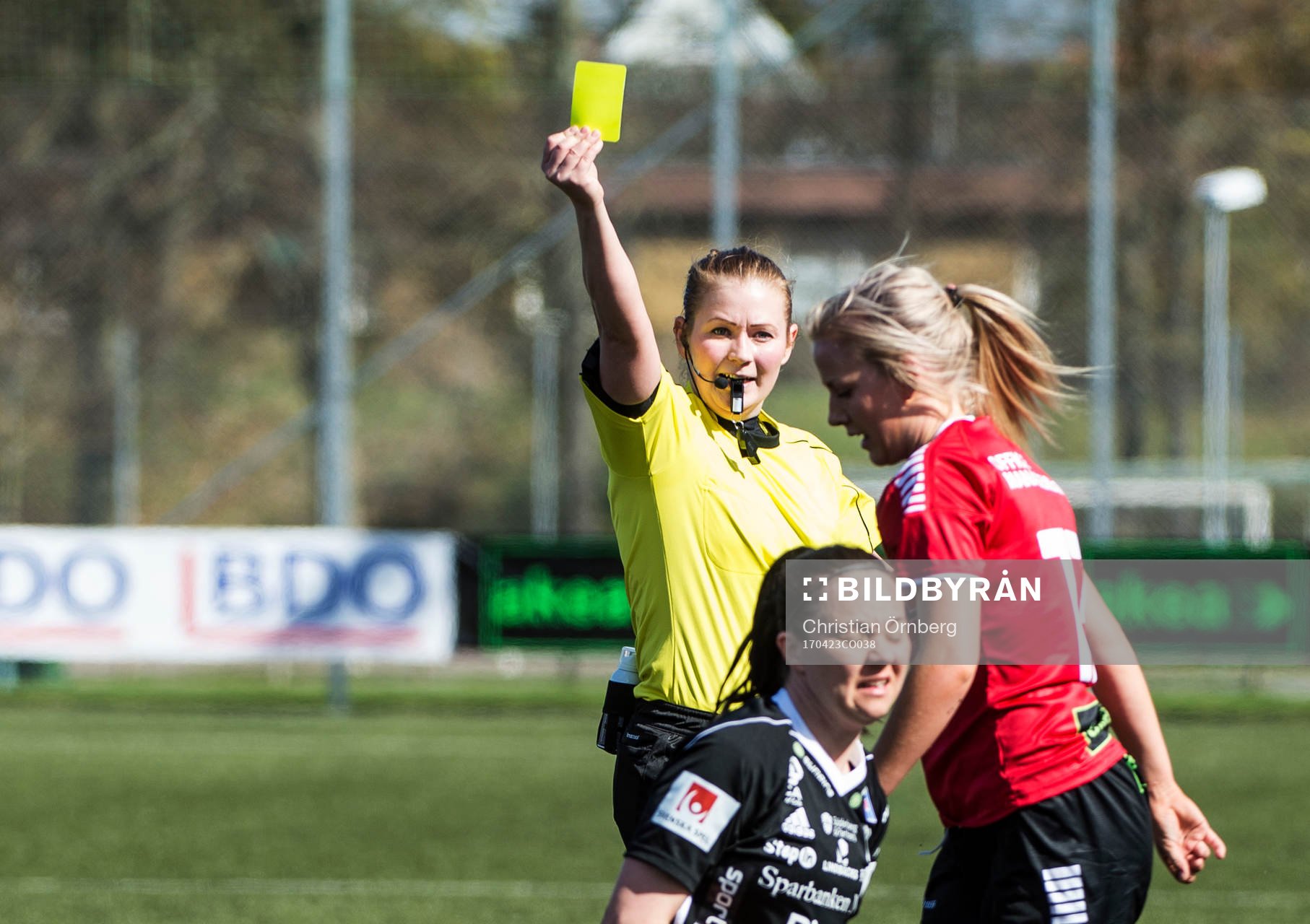 Domaren Laura Rapp höjer det gula kortet