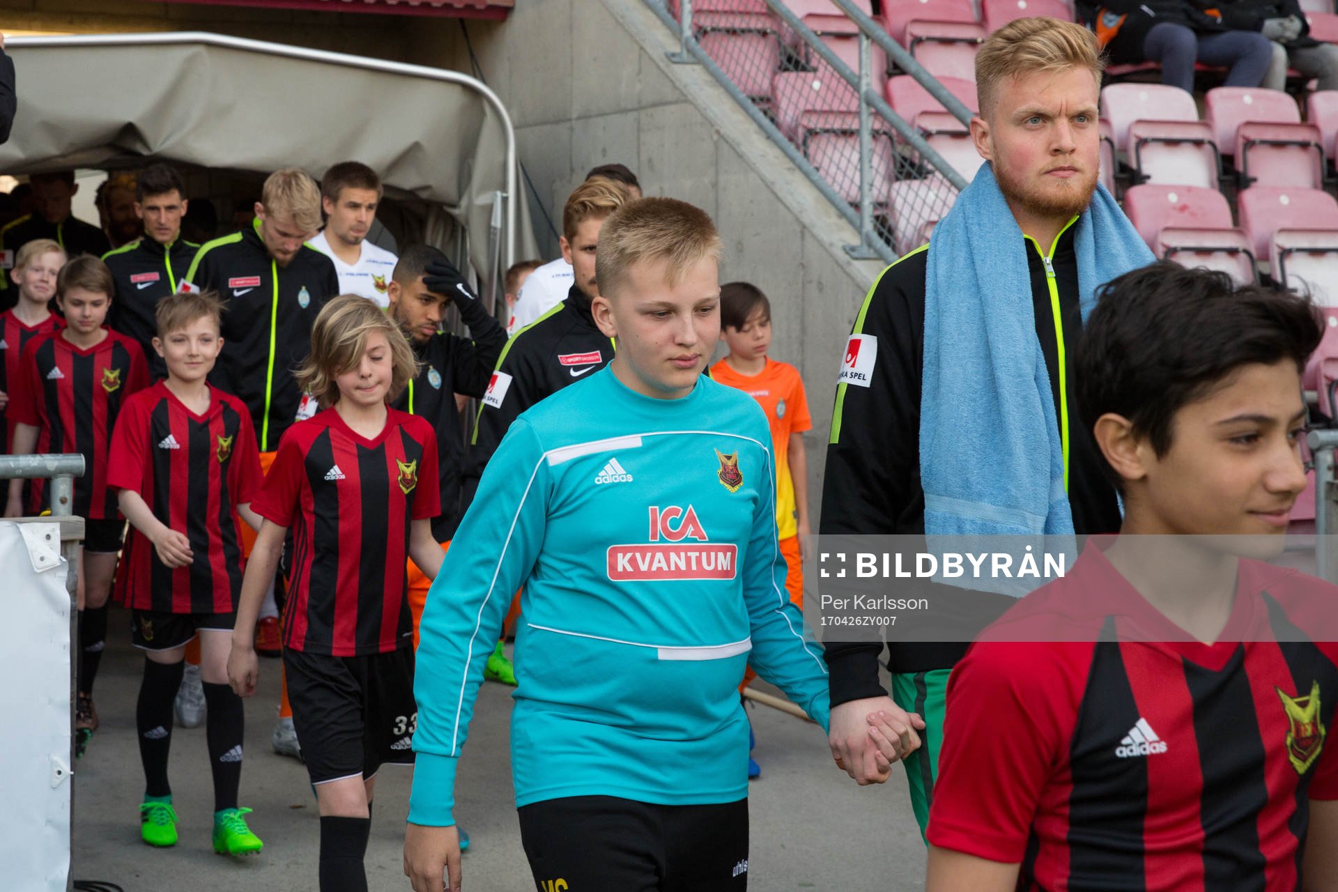 Spelare går in på planen innan fotbollsmatchen i
