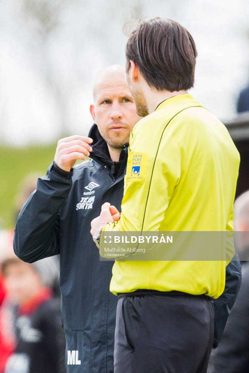 Tvååkers tränare Mattias Lindström i diskussion med domare Jovan Bjelajac under fotbollsmatchen i Division 2 Västra Götaland mellan Hittarp och Tvååker den 29 april 2017 i Helsingborg.