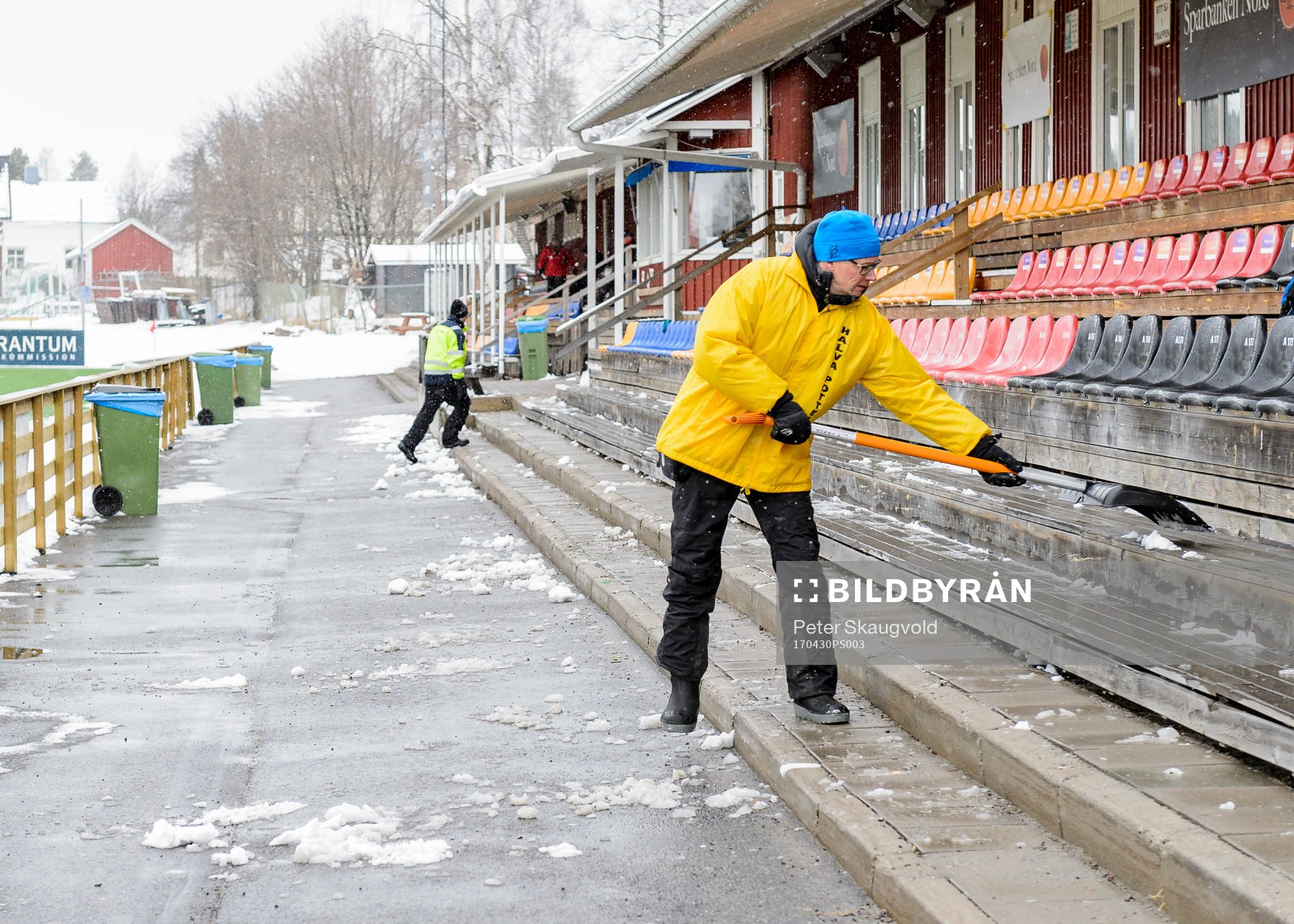 En funktionär skottar bort snö från sittplats