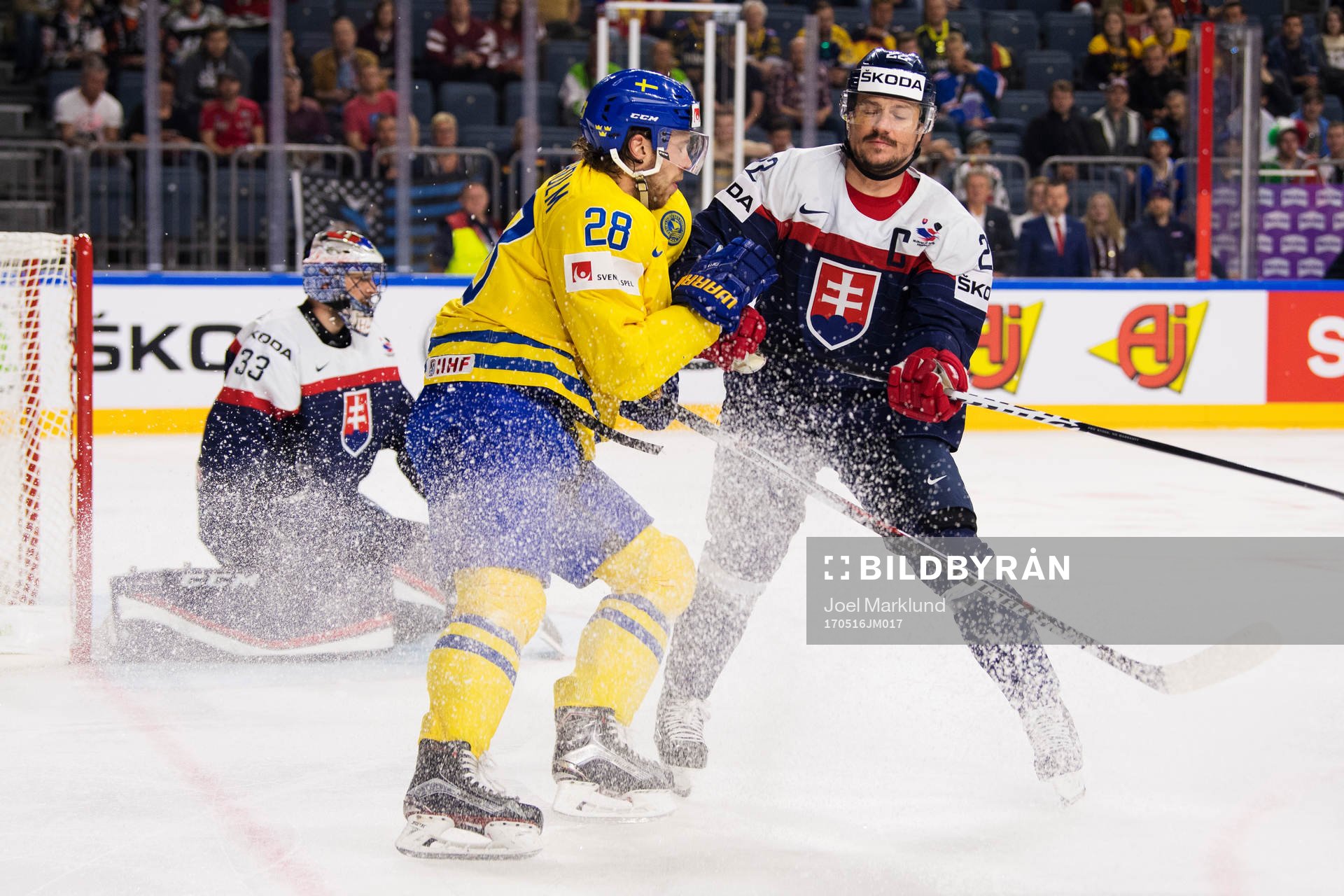 Sveriges Elias Lindholm blir tacklad av Slovakiens Vladimir