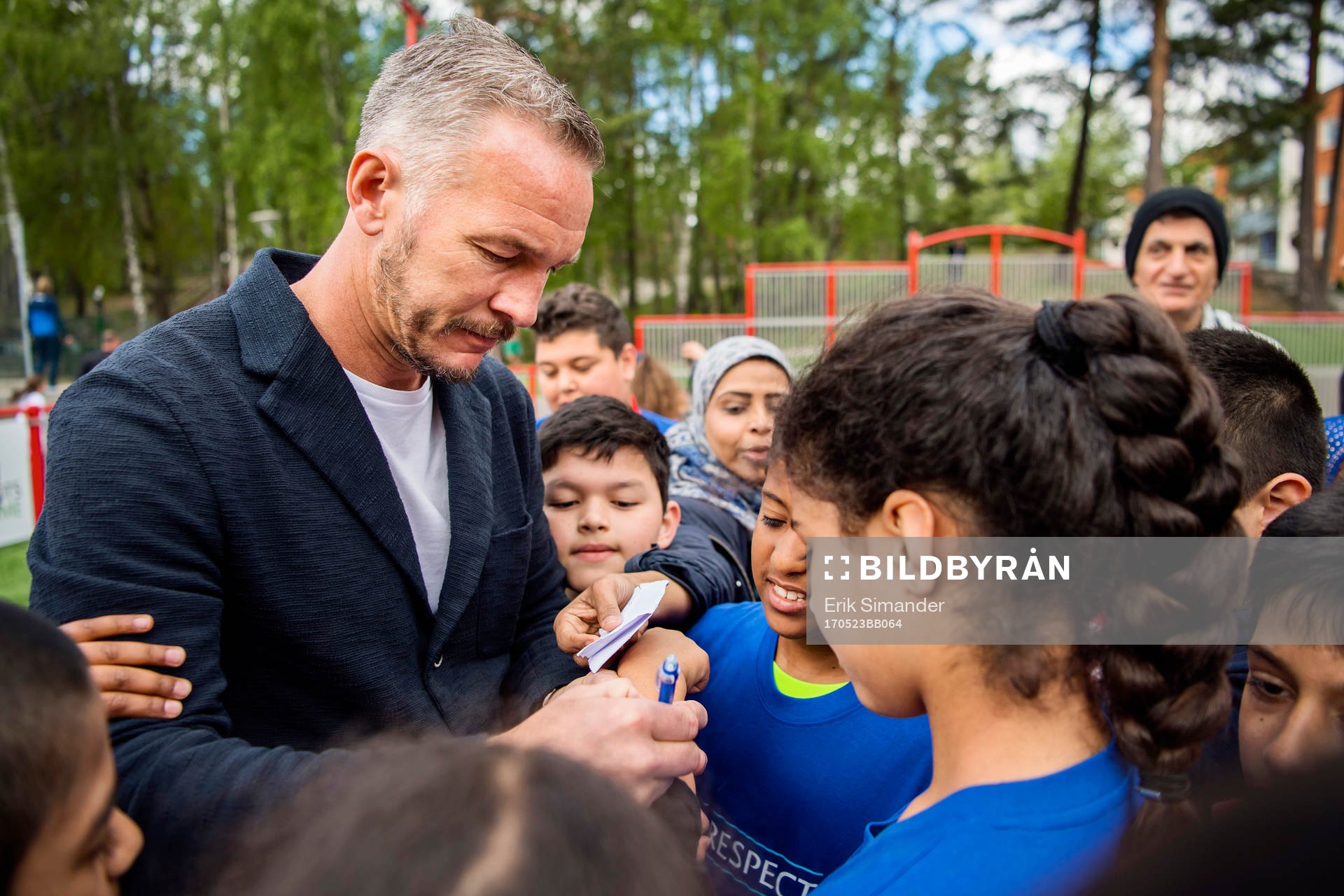 Patrik Andersson, UEFA Europa League-finalens ambassadör skriver autografer under invigningen av den UEFA-skänkta konstgräsplanen den 23 maj 2017 i Husby. 