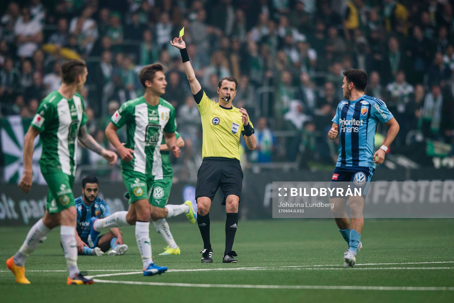 Domare Andreas Ekberg delar ut ett gult kort till Hammarbys
