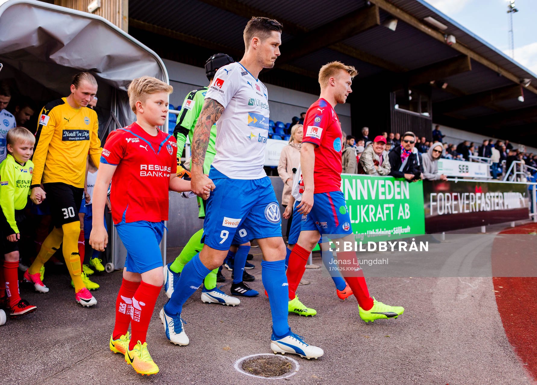 Värnamos Pär Cederqvist och Helsingborgs Andreas Landgren på väg ut till match tillsammans med knattar under fotbollsmatchen i Superettan mellan Värnamo och Helsingborg den 26 juni 2017 i Värnamo.