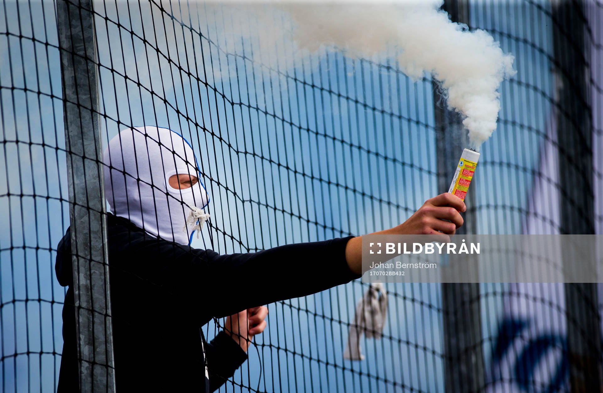 En maskerad Norrköpingssupporter med pyroteknik