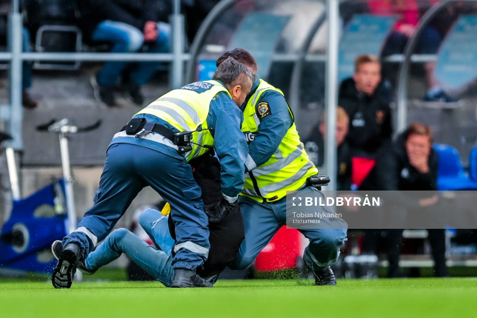 Person brottas ner av vakter