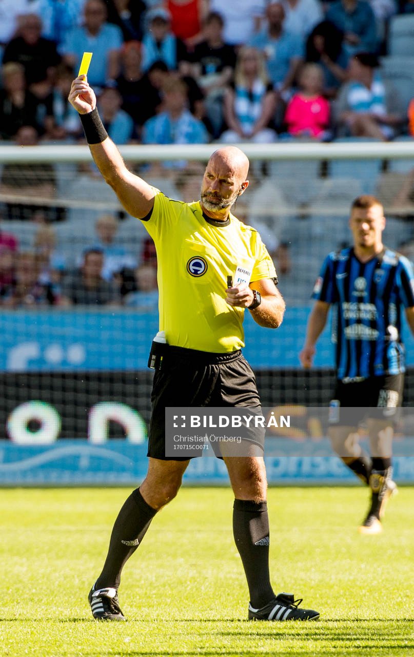 Domaren Stefan Johannnesson höjder det gula kortet