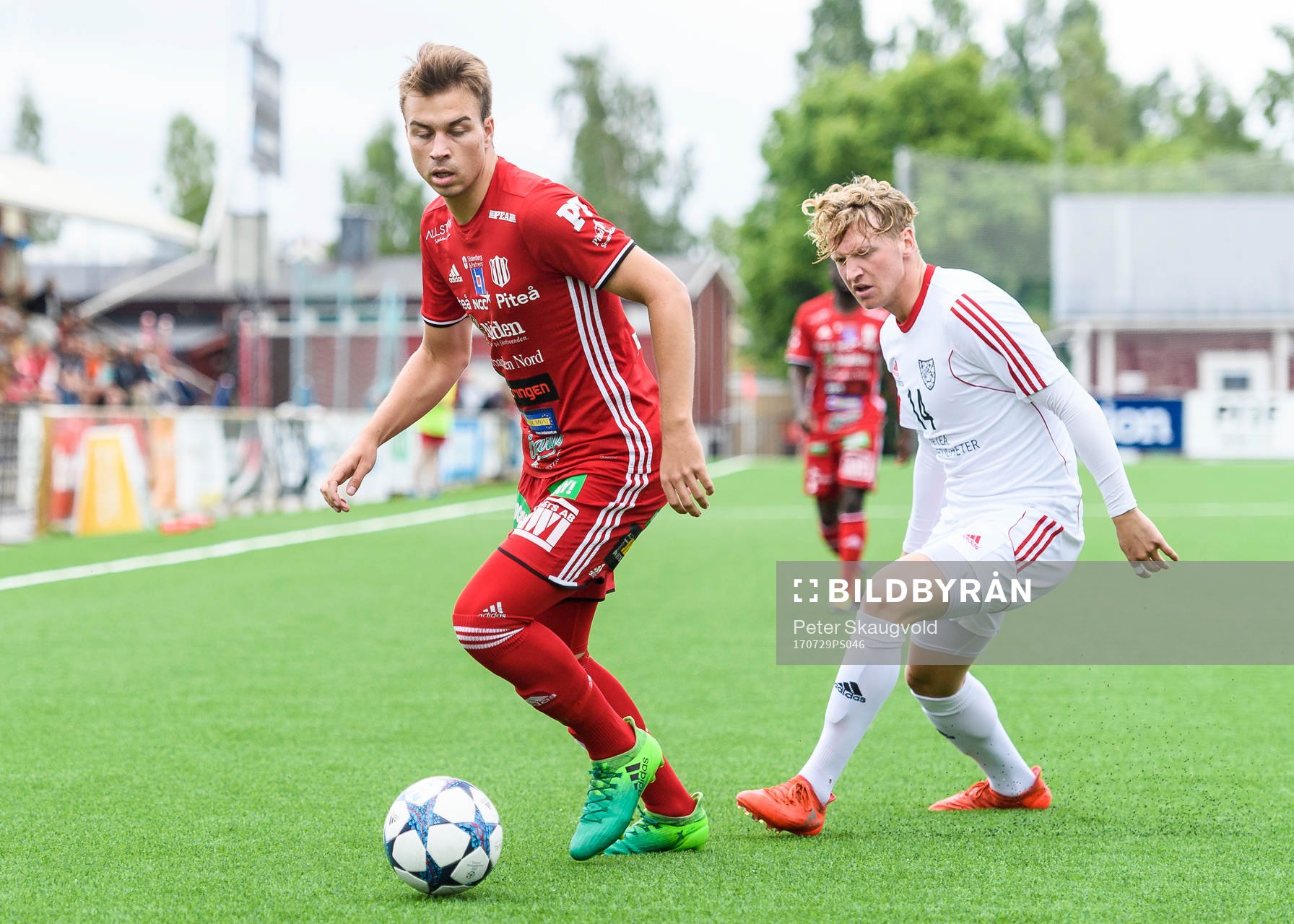 Piteås Alex Naylor med bollen uppvaktas av Täfteås Axel Fällman under fotbollsmatchen i Division 2 Norrland mellan Piteå och Täfteå den 29 Juli 2017 i Piteå.