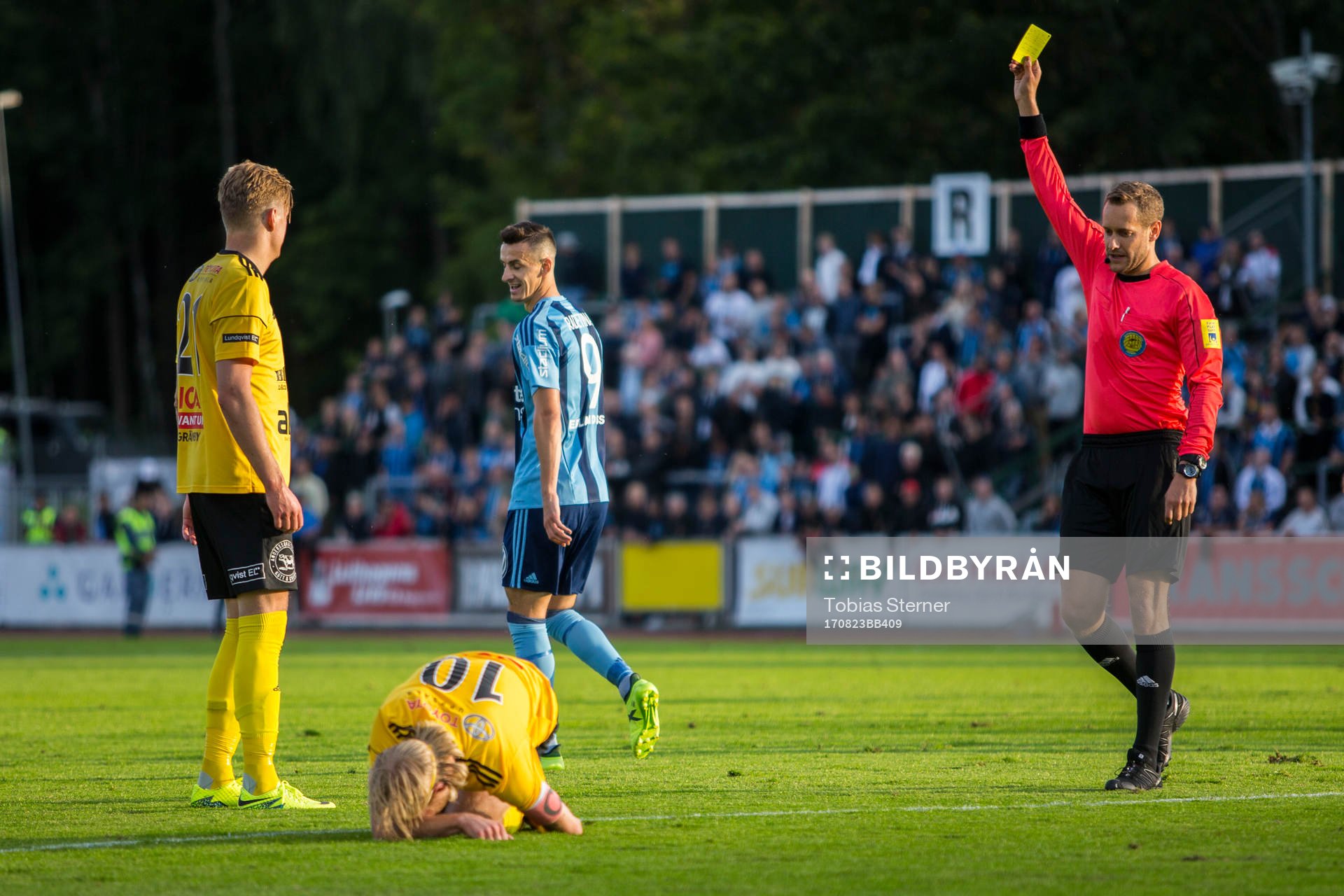 Domare Victor Wolf delar ut ett gult kort till Haris