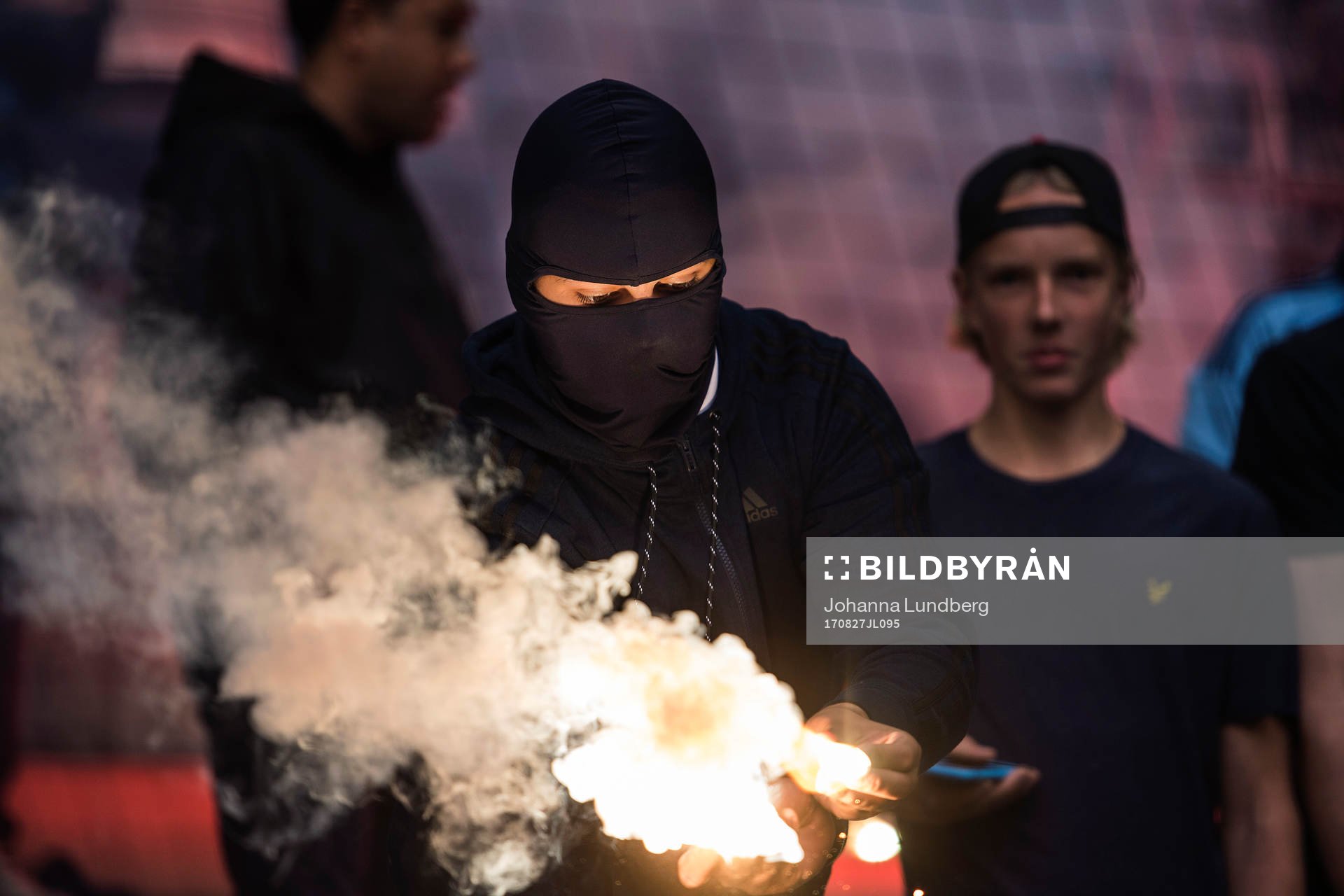 En av Djurgårdens supportrar håller i en bengal
