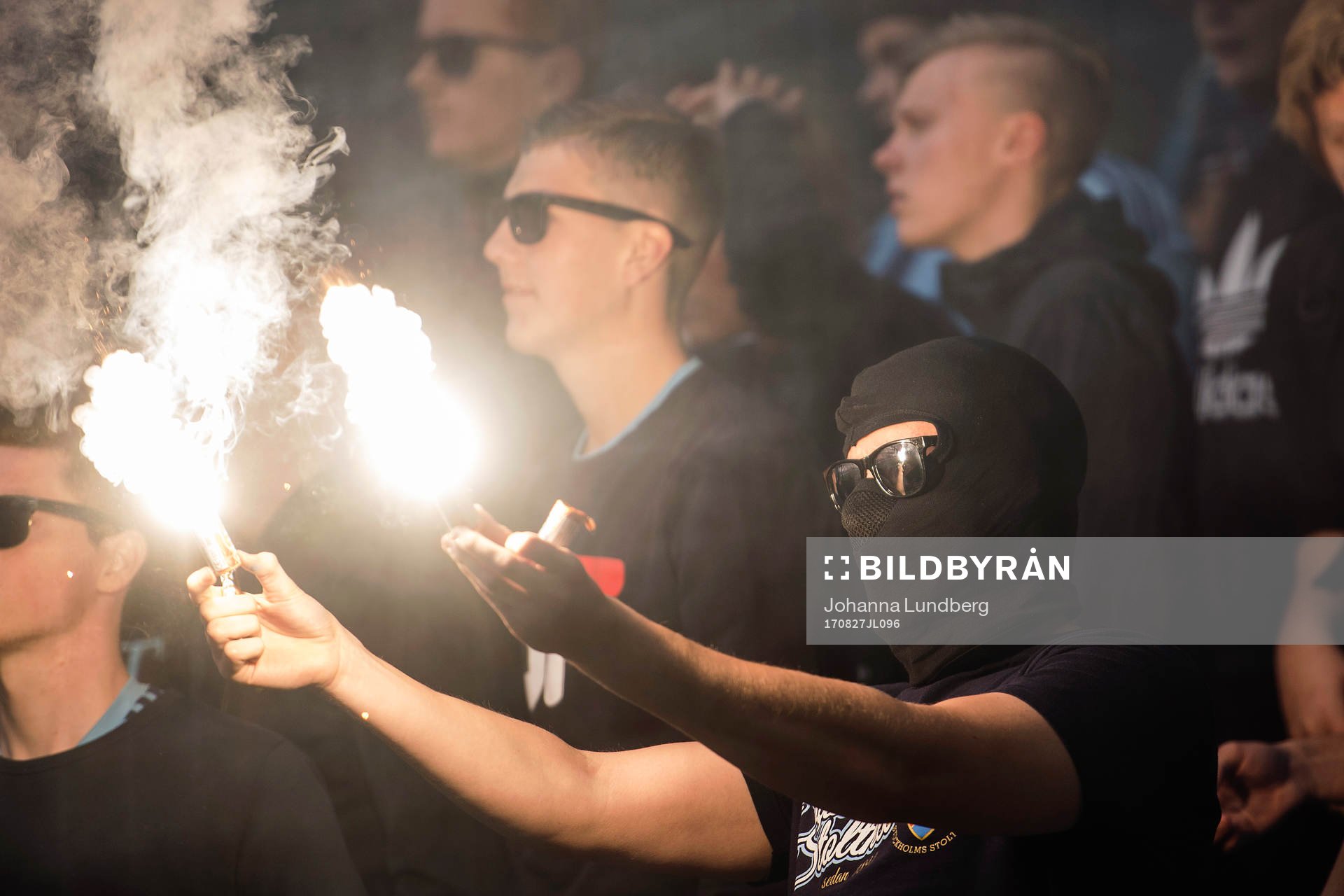 En av Djurgårdens supportrar håller i en bengal