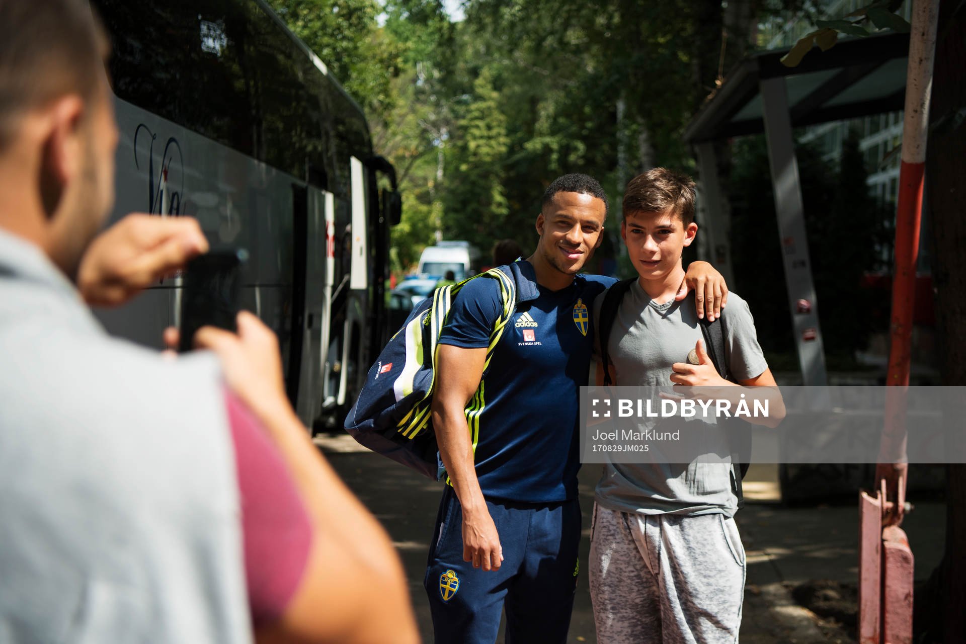 Martin Olsson ställer upp på ett foto med ett ungt fan