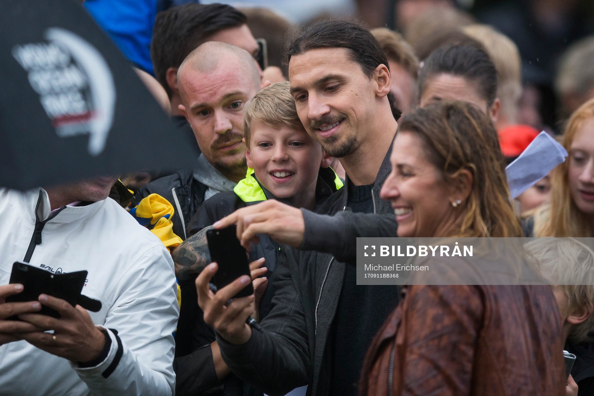 Zlatan Ibrahimovic tar en bild med en ung supporter
