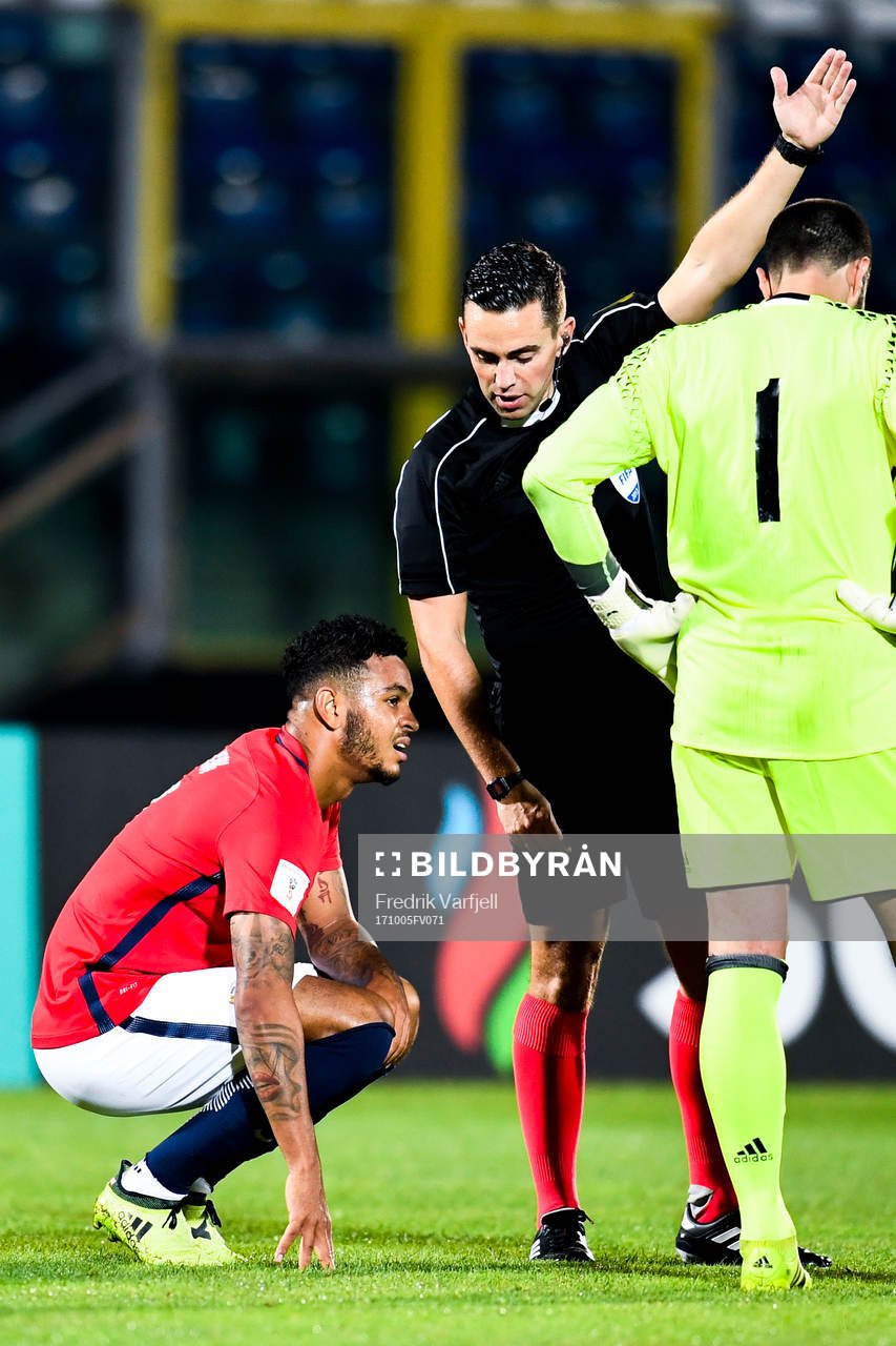 Joshua King of Norway sitting down with an injury and