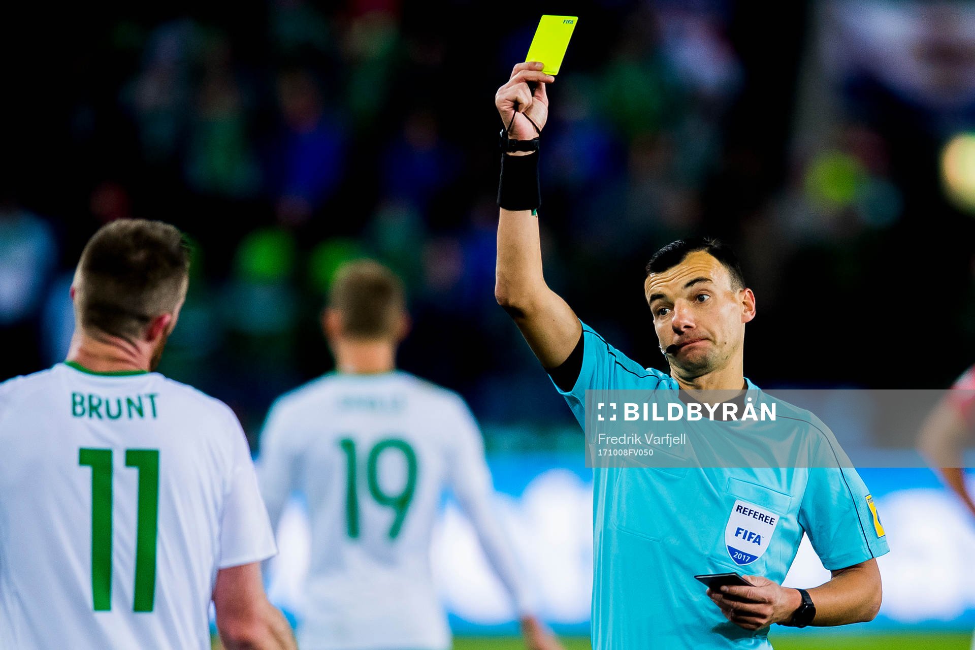Chris Brunt of Northern Ireland is shown the yellow card by