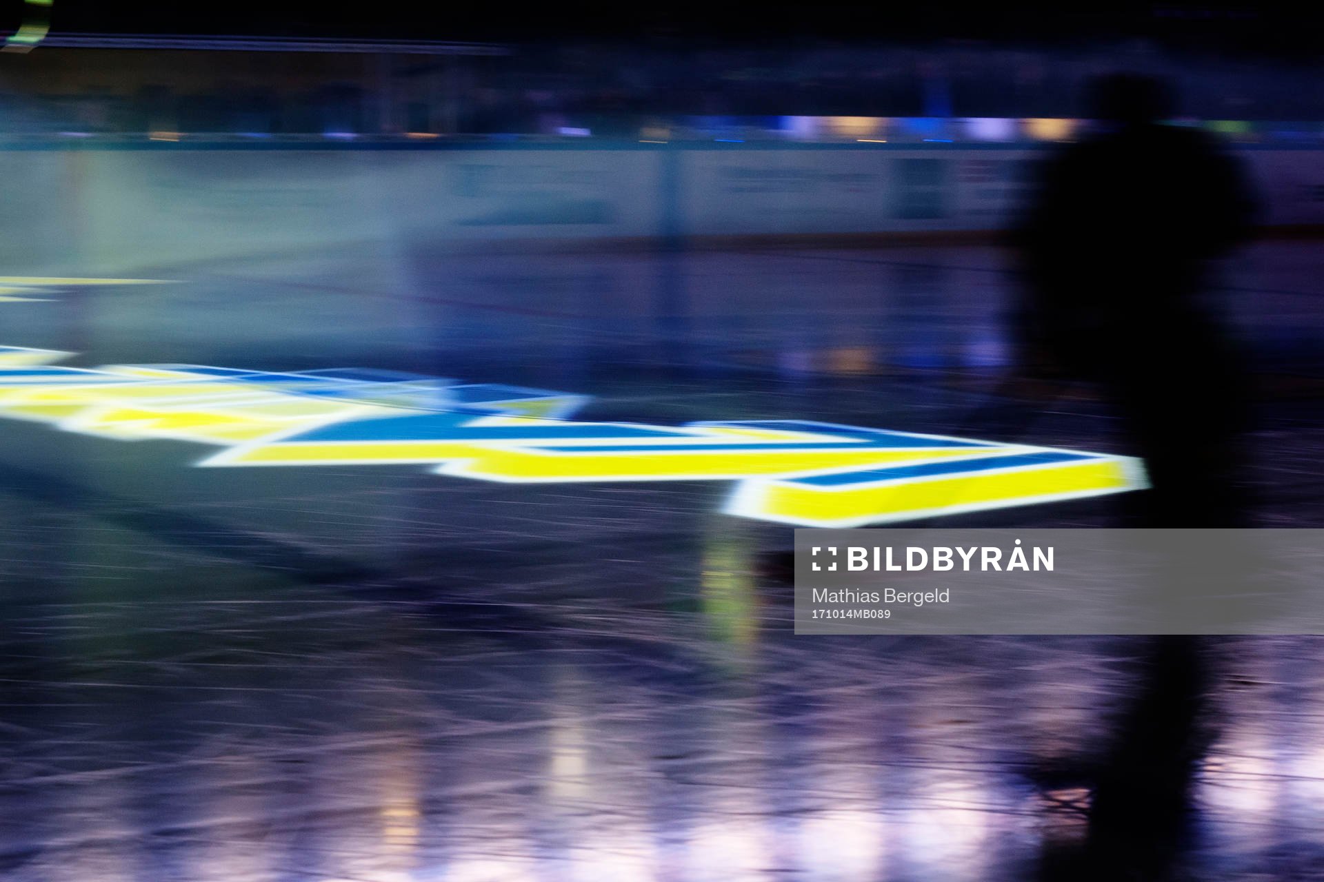 Skuggan av en spelare syns mot en projicerad HV71-logotyp