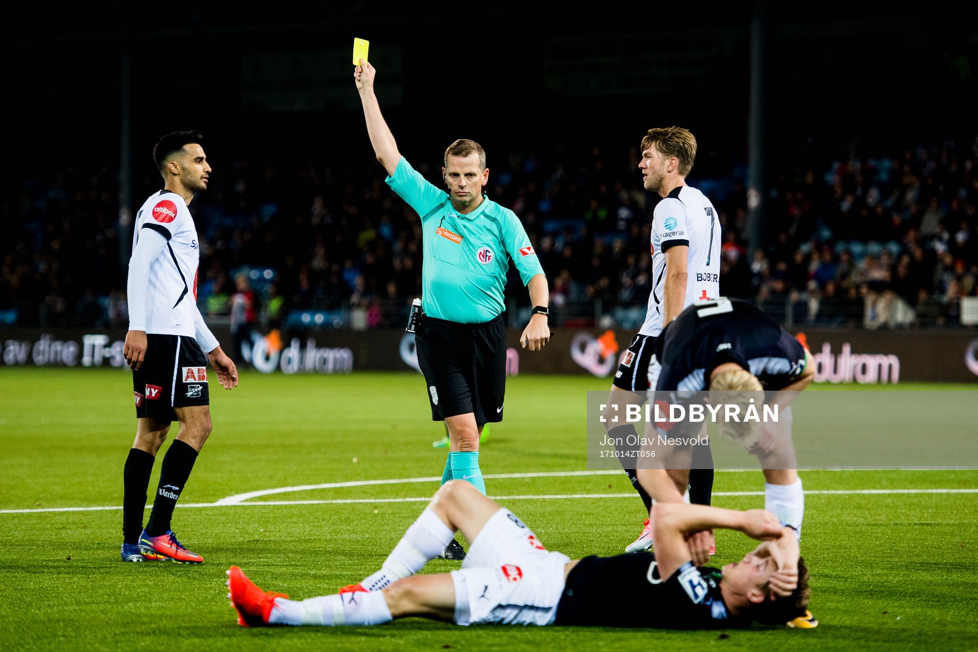 Trygve Kjensli, referee, gives a yellow card to Etzaz Hussain of Odd during the Eliteserien match between Strømsgodset and Odd on October 14, 2017 in Drammen.