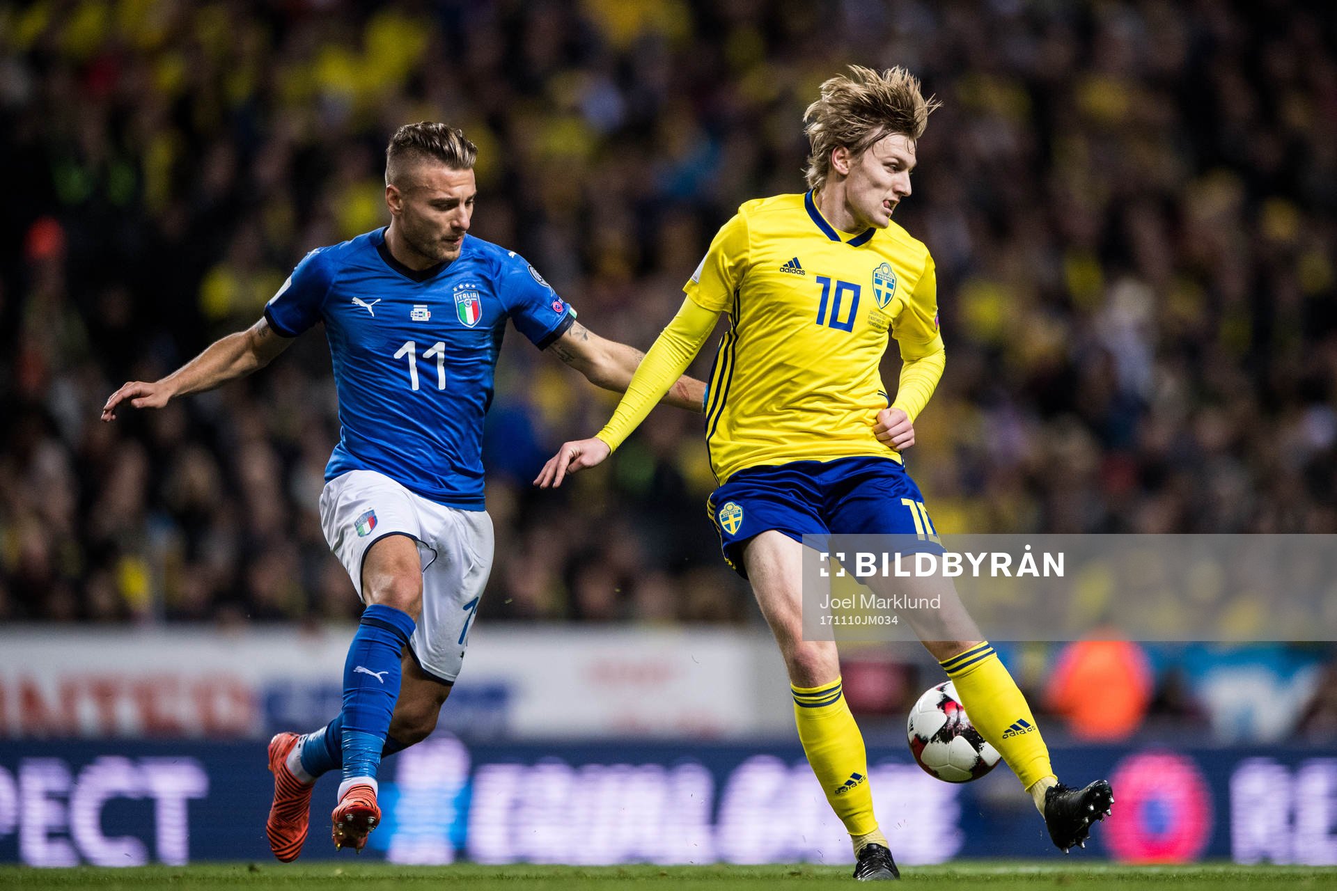 Sveriges Emil Forsberg klackar bollen bredvid Italiens Ciro