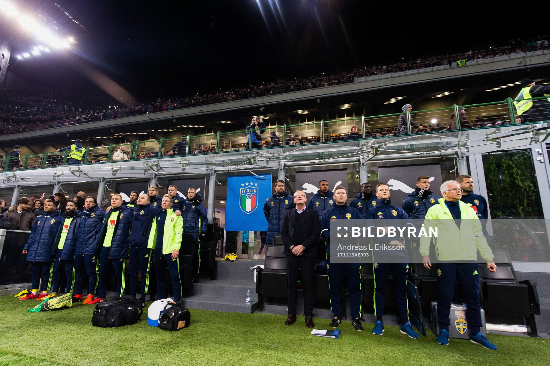 De svenska spelarna på bänken sjunger nationalsången tillsammans med förbundskapten Janne Andersson och assisterande förbundskapten Peter Wettergren innan fotbollsmatchen i VM-kvalets play-off mellan Italien och Sverige den 13 november 2017 i Milano.