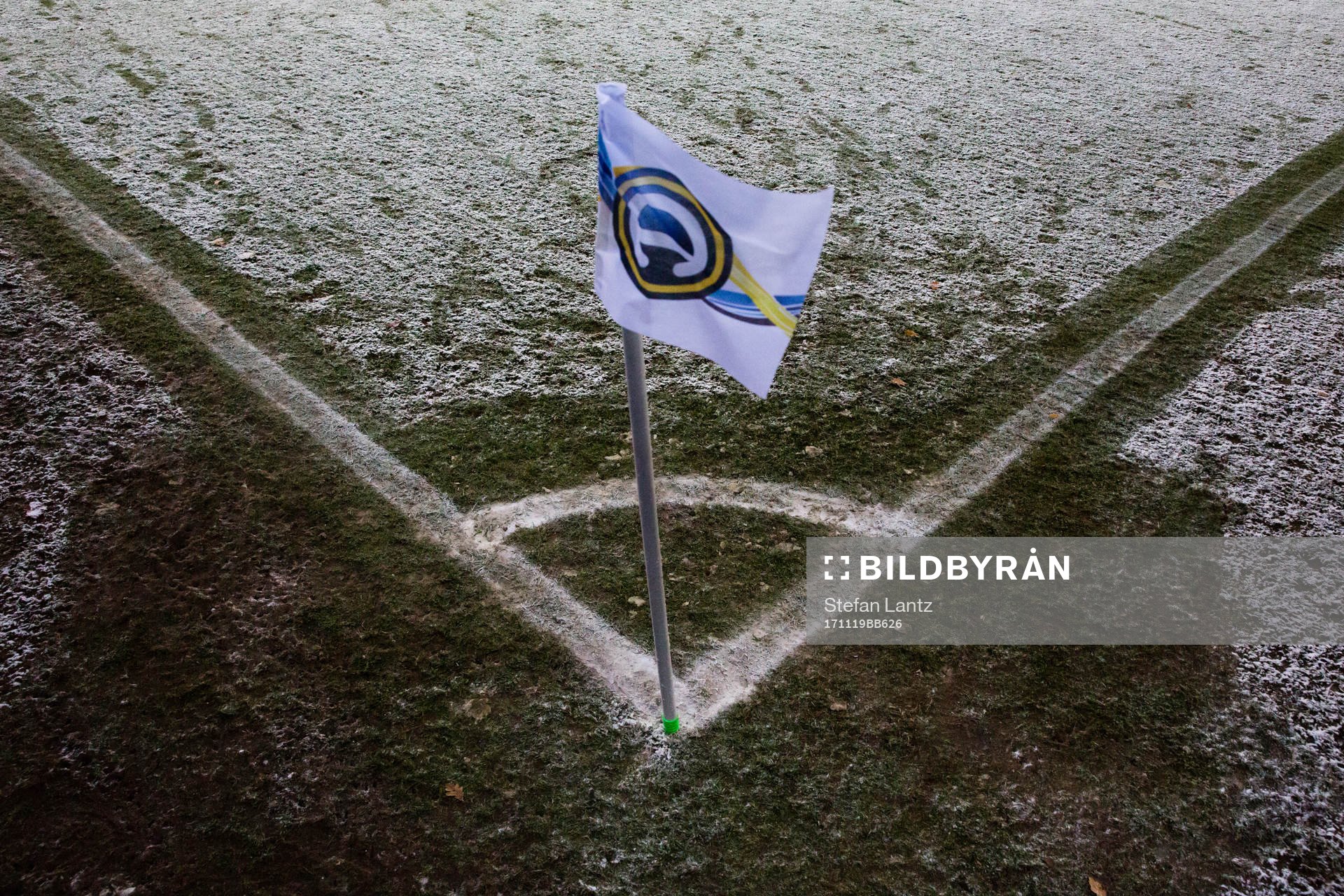 Snö på gräset runt hörnflaggan
