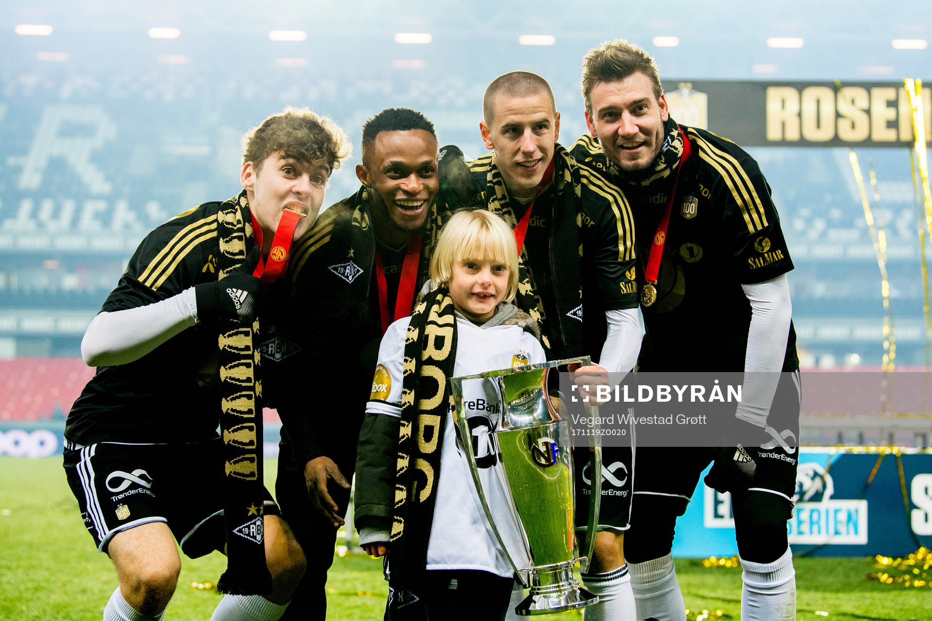 Nicklas Bendtner of Rosenborg celebrates winning the league together with his son Nicholas and teammates Jacob Rasmussen, Samuel Adegbenro and Milan Jevtovic after the Eliteserien match between Rosenborg and Viking on November 19, 2017 in Trondheim.