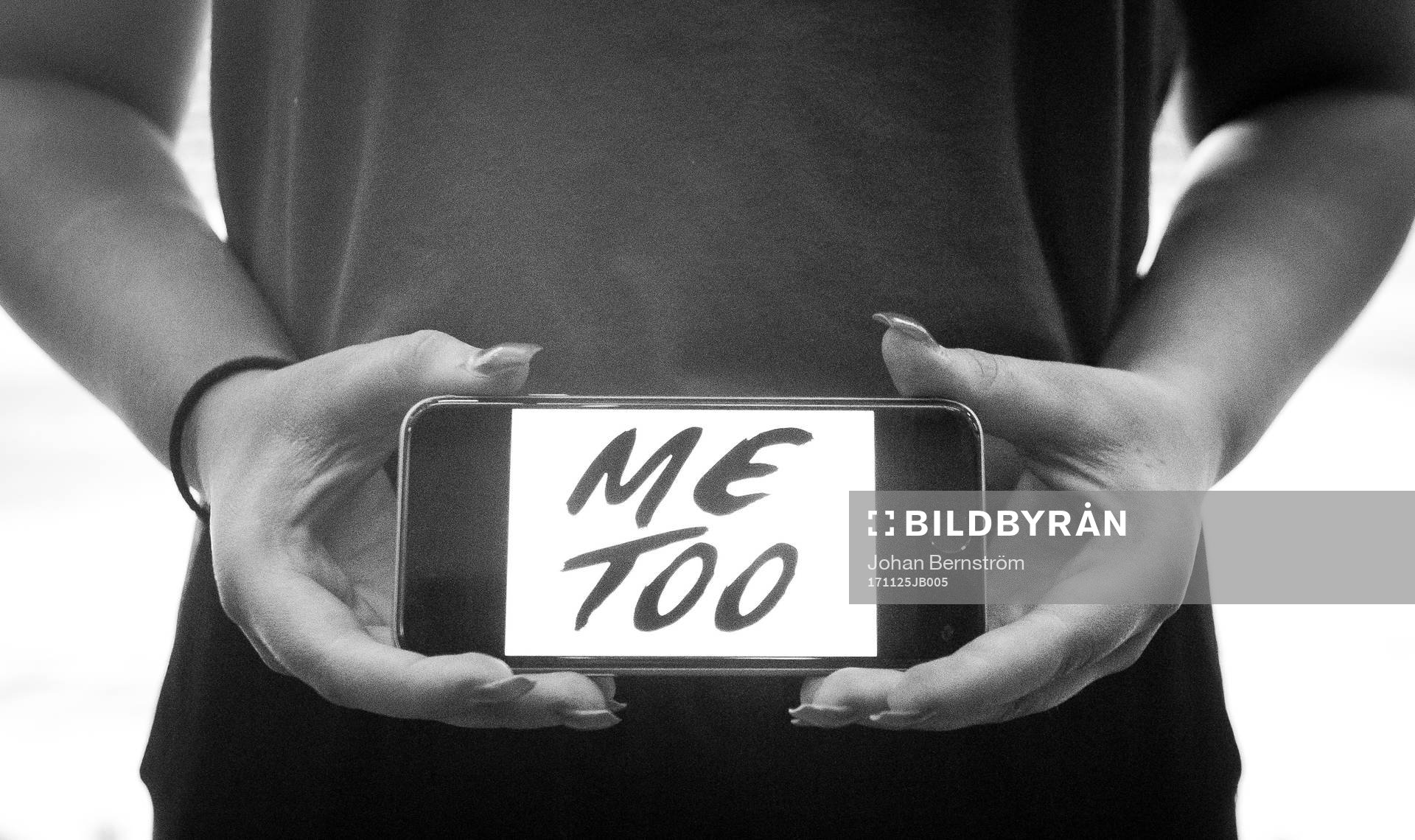 En tjej håller upp en telefon med texten Metoo