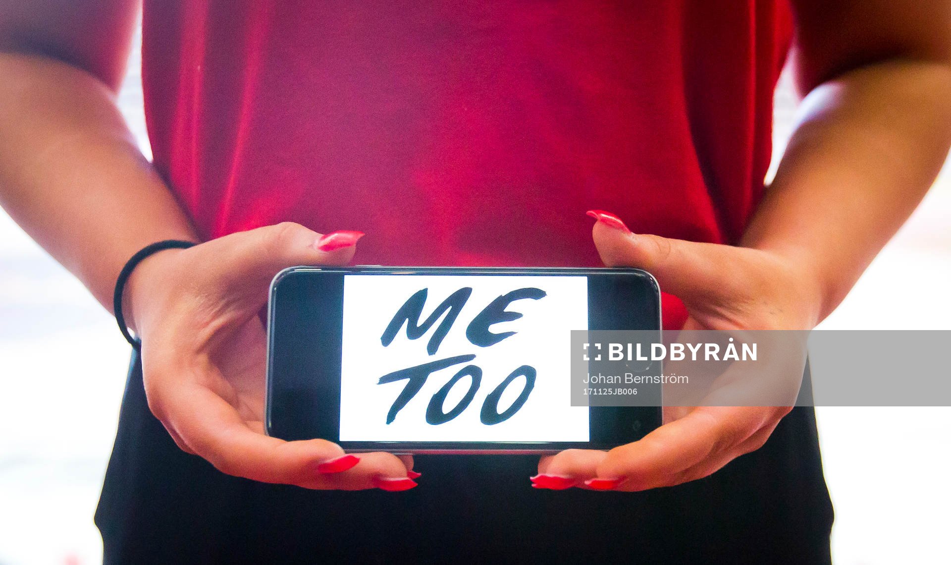 En tjej håller upp en telefon med texten Metoo