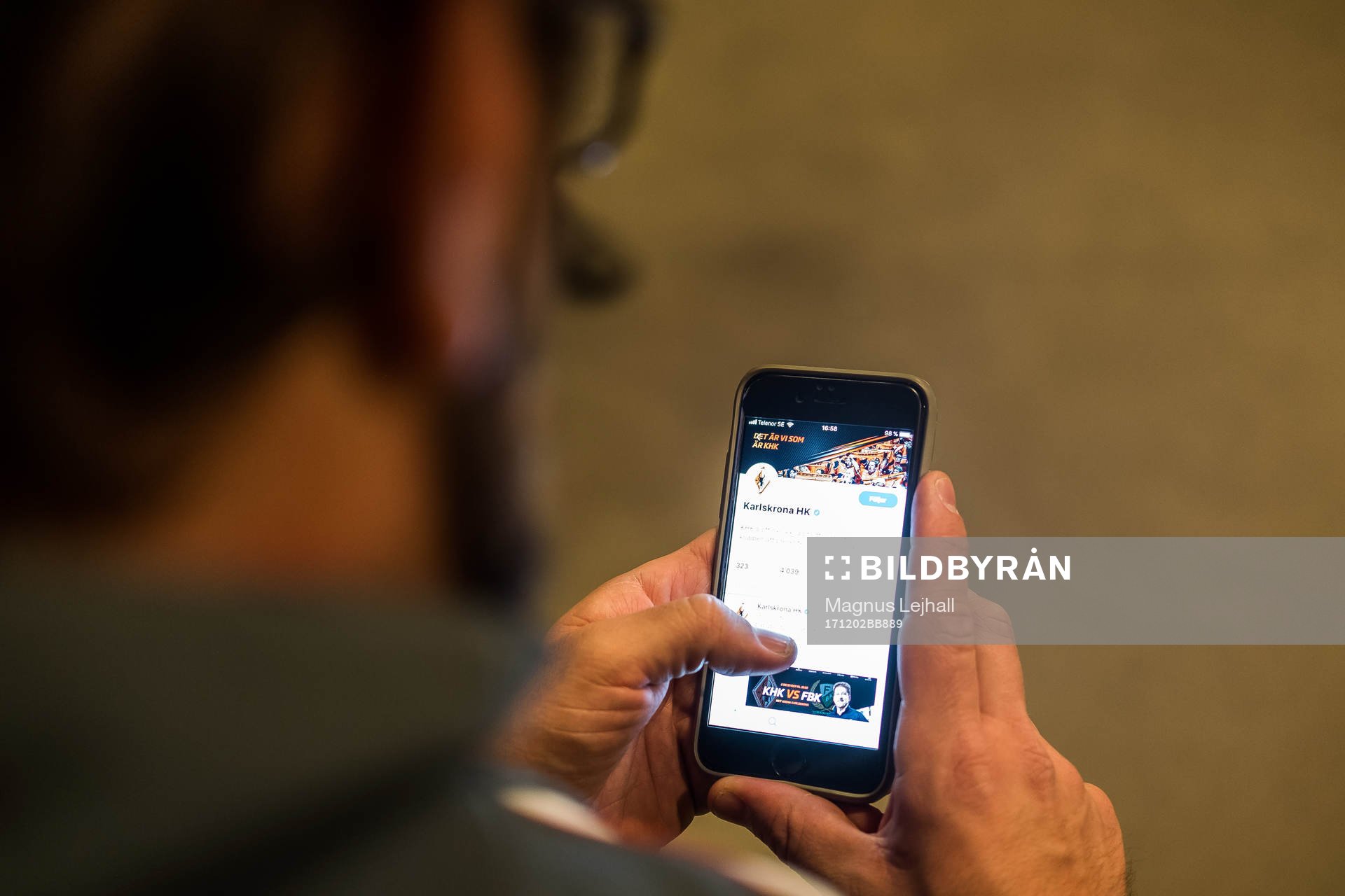Man tittar på KHK officiella twitterkonto på mobilen