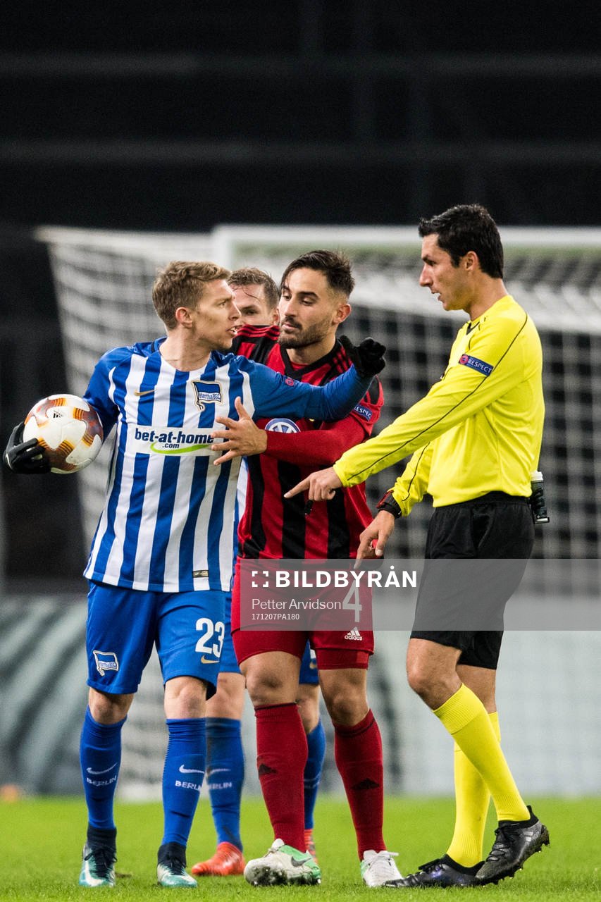 Hertha Berlins Mitchell Weiser vill inte släppa ifrån sig bollen till Östersunds Sotirios Papagiannopoulus och domare Tiago Martins under fotbollsmatchen i Europa League mellan Hertha Berlin och Östersund den 7 december 2017 i Berlin.