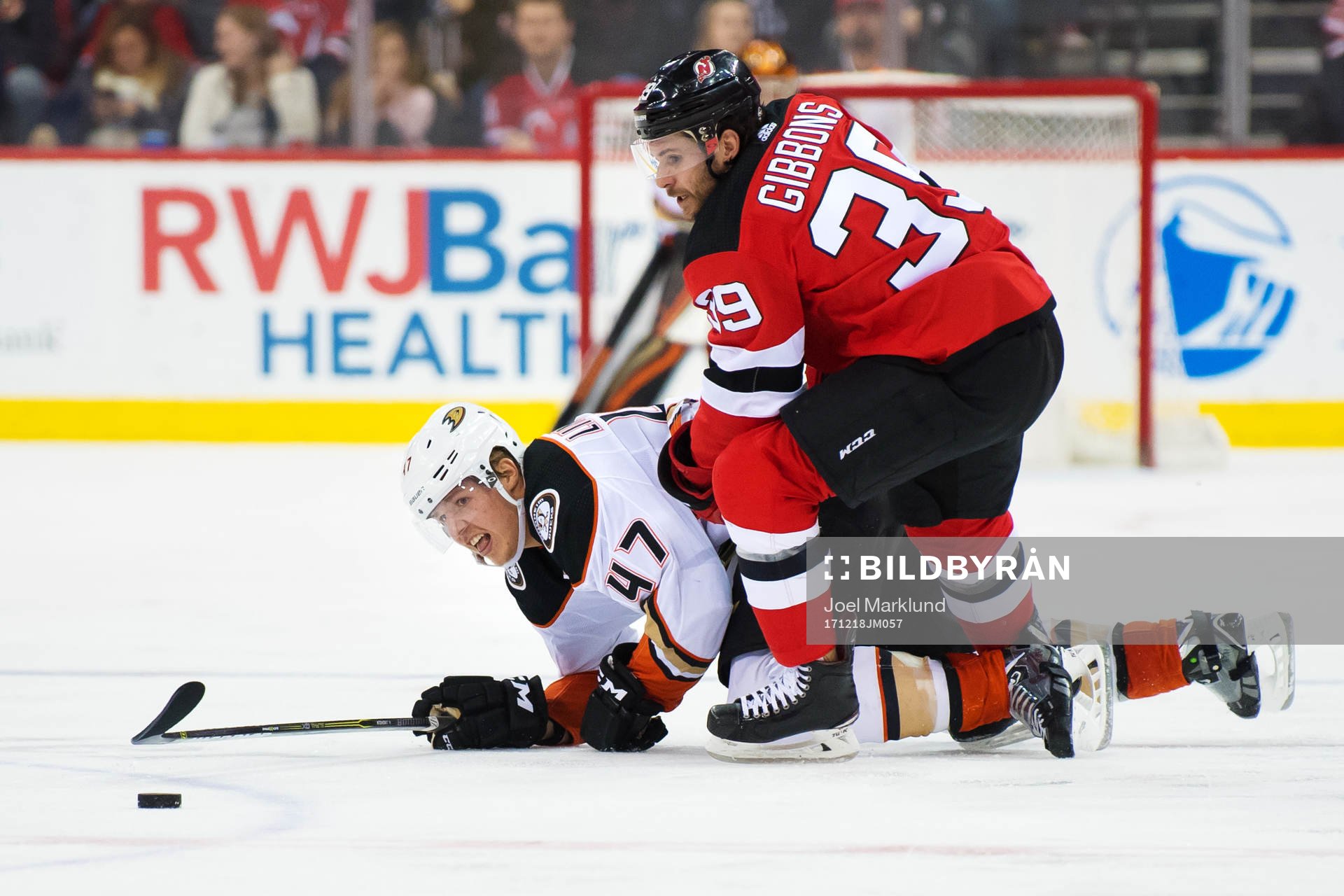 Ducks Hampus Lindholm tacklas av Devils Brian Gibbons