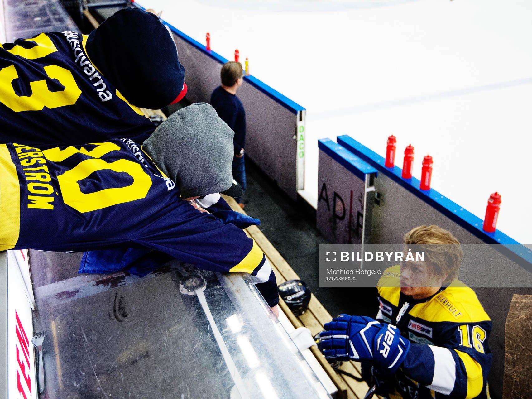 Två unga HV71-supportrar sträcker händerna mot Tom